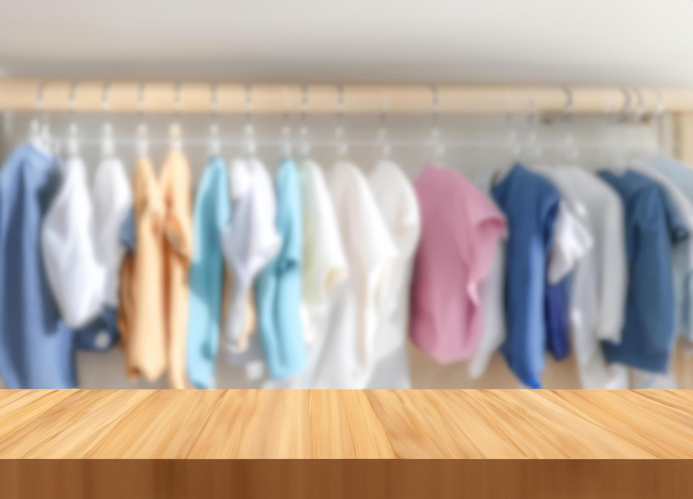 Wood table with blurred children’s clothes hanging Stock Free