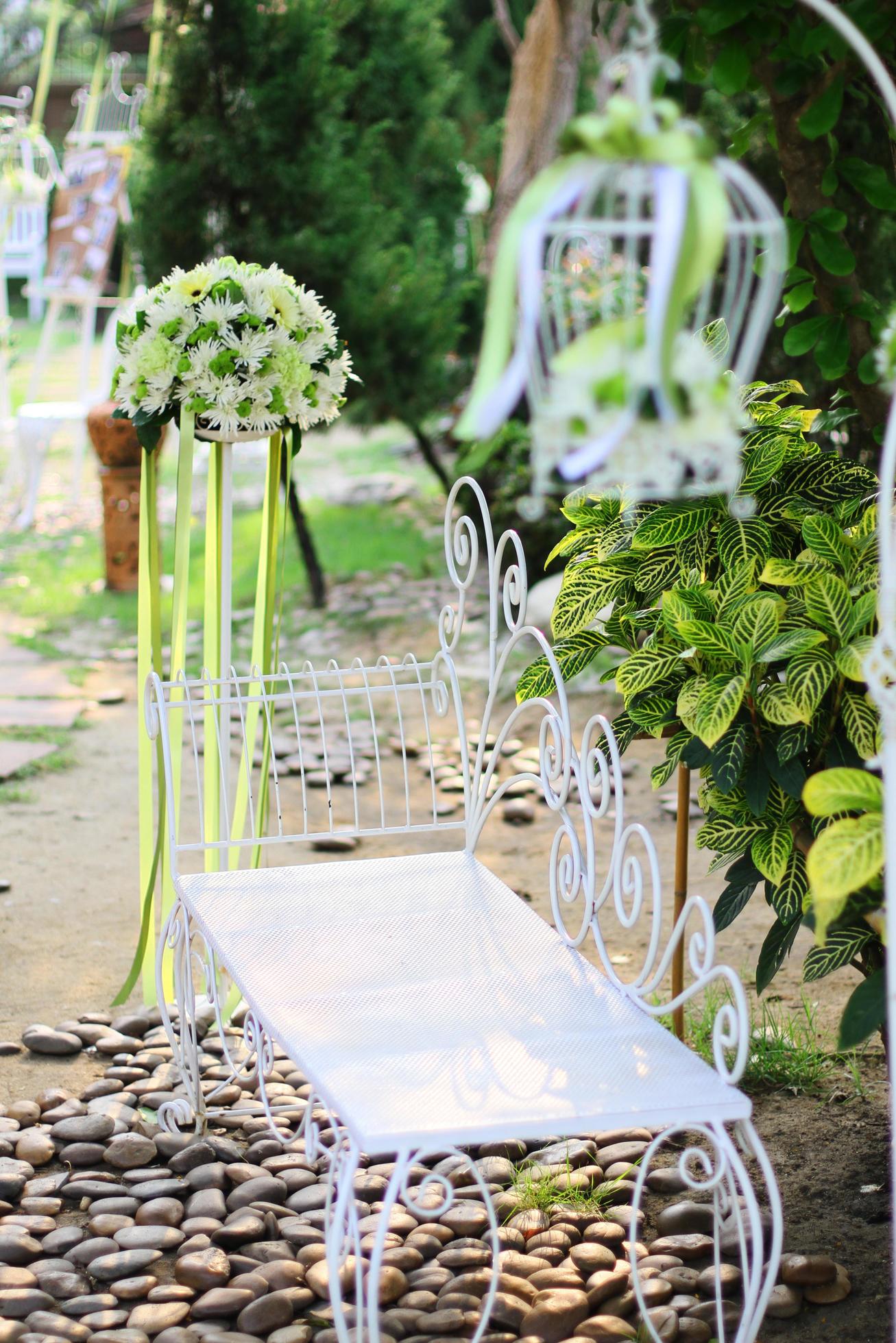 White birdcage, chair decoration with roses and white flowers hanging decoration in garden for wedding ceremony Stock Free