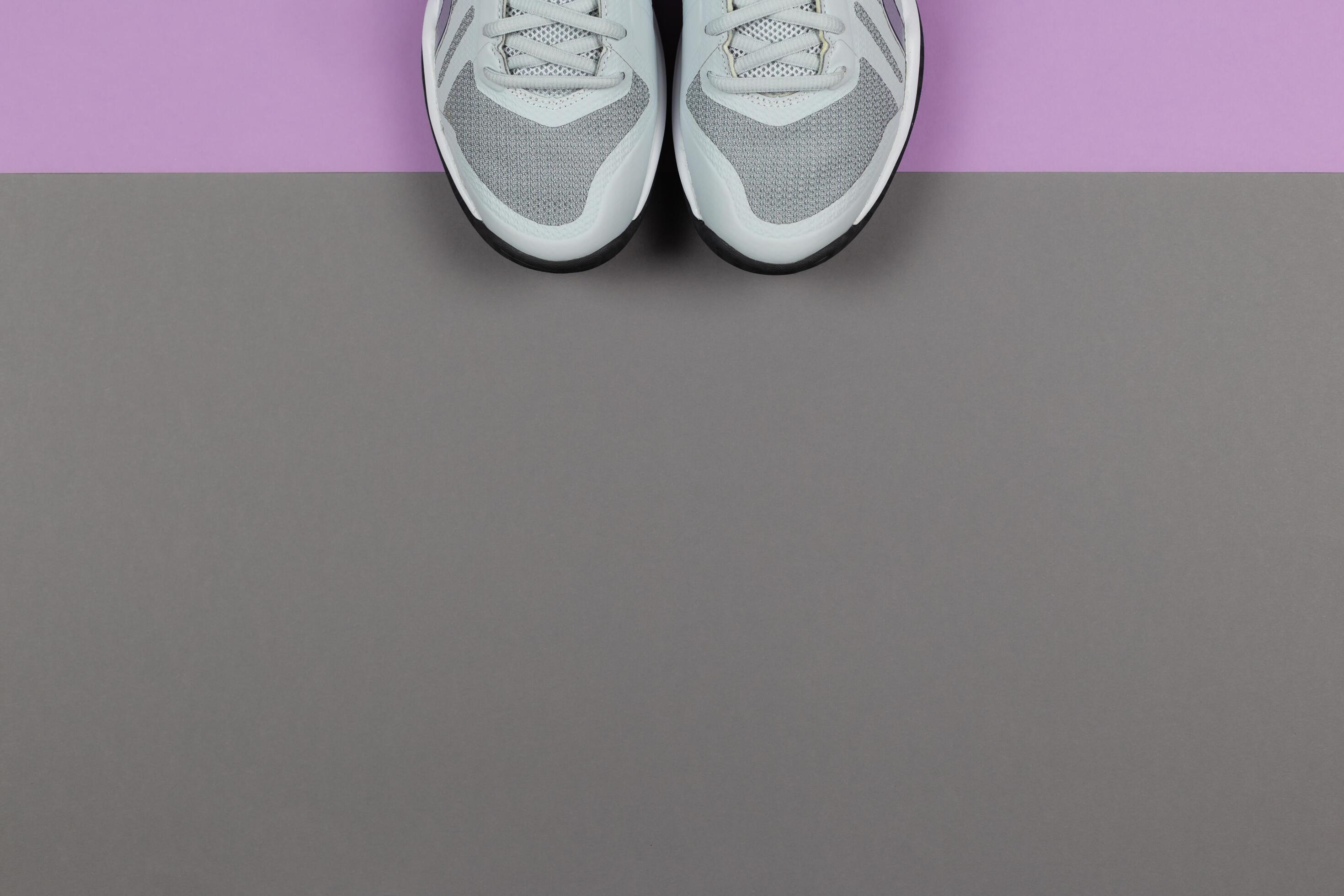 Grey sneakers on the violet and grey background. Concept for healthy lifestyle and everyday training. Stock Free