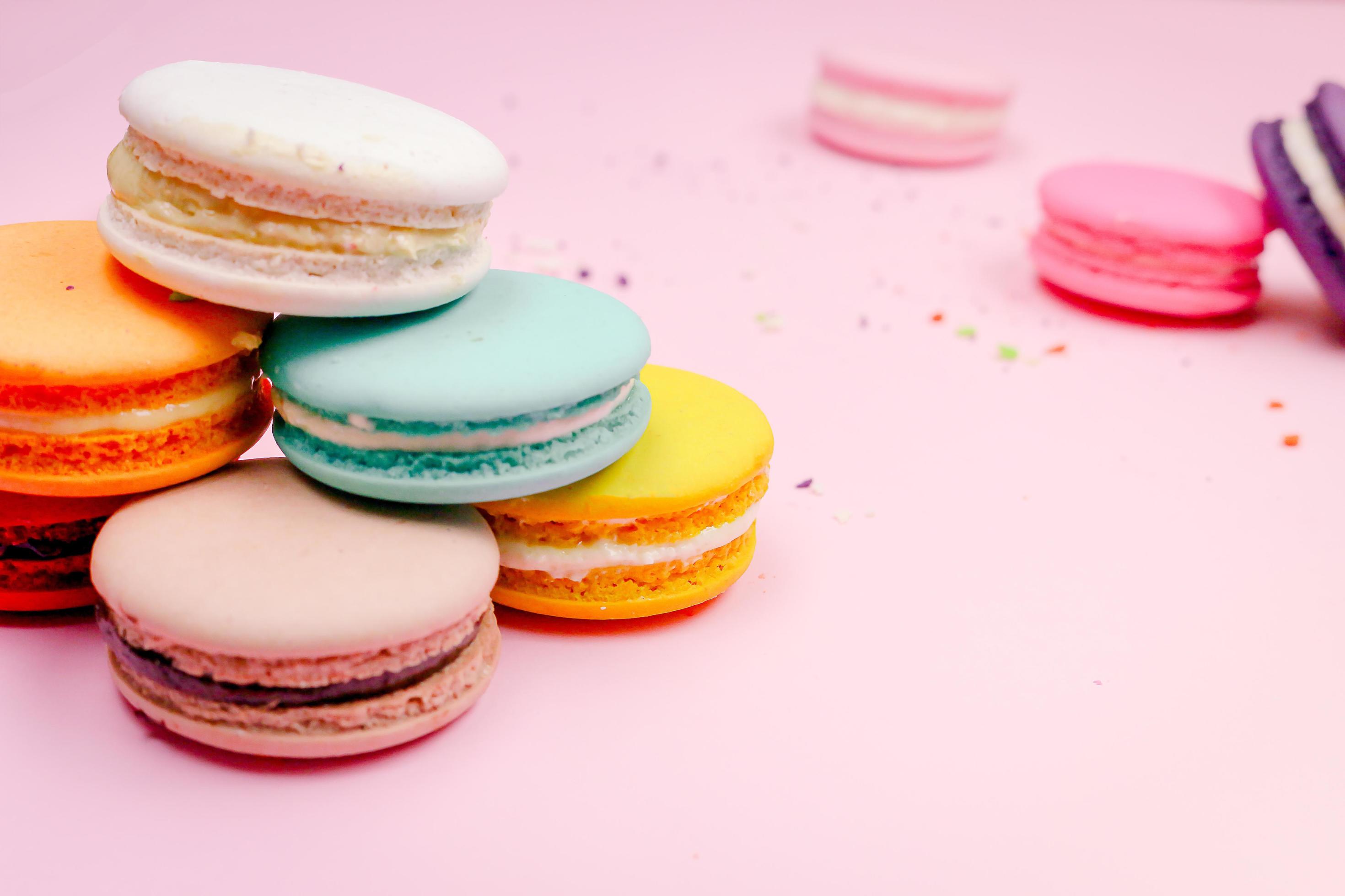 Colorful french macarons macaroons cake, delicious sweet dessert on a pink background with copyspace, food background concept. Stock Free