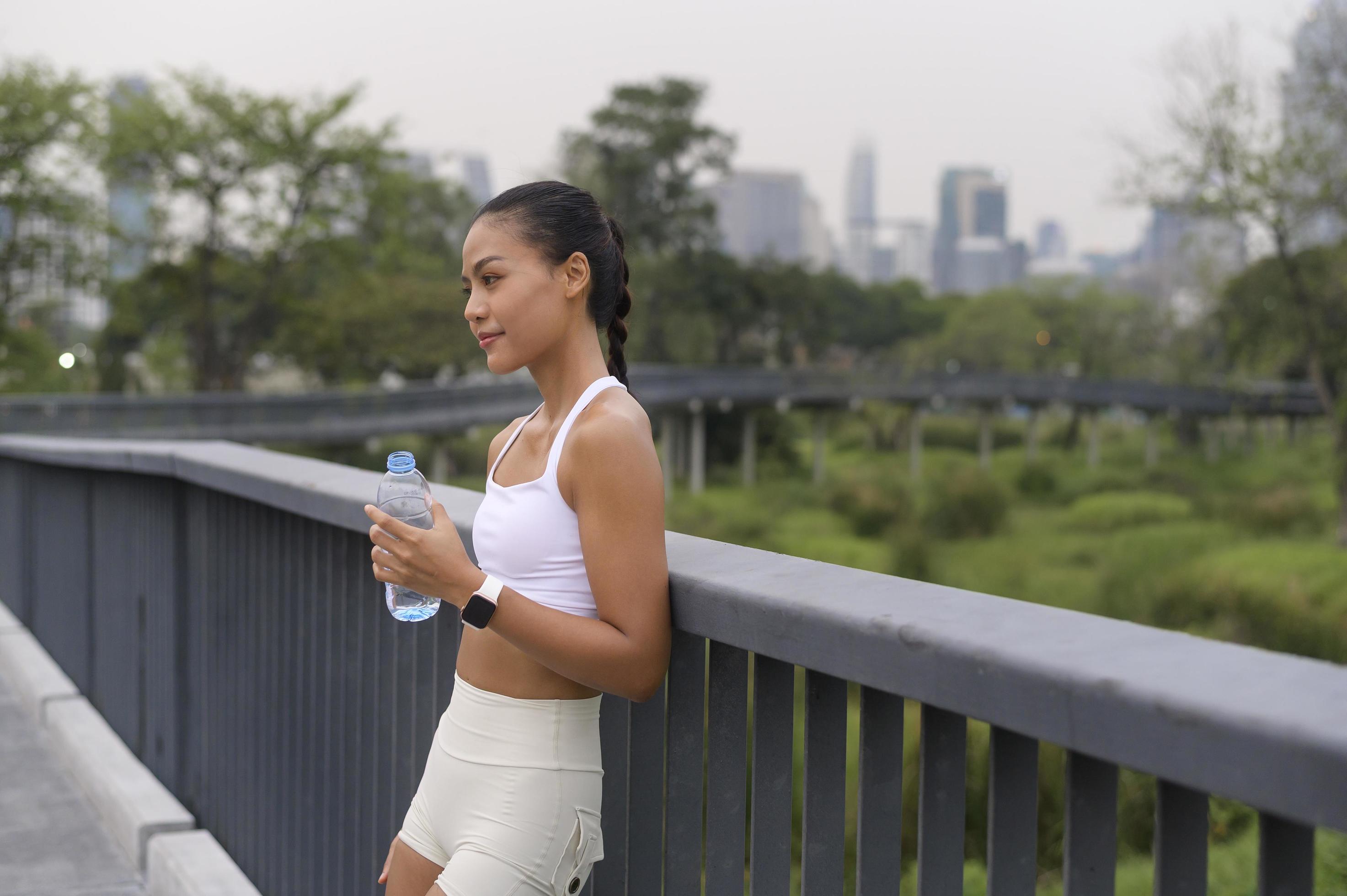 Young fitness woman in sportswear drinking water in city park, Healthy and Lifestyles. Stock Free