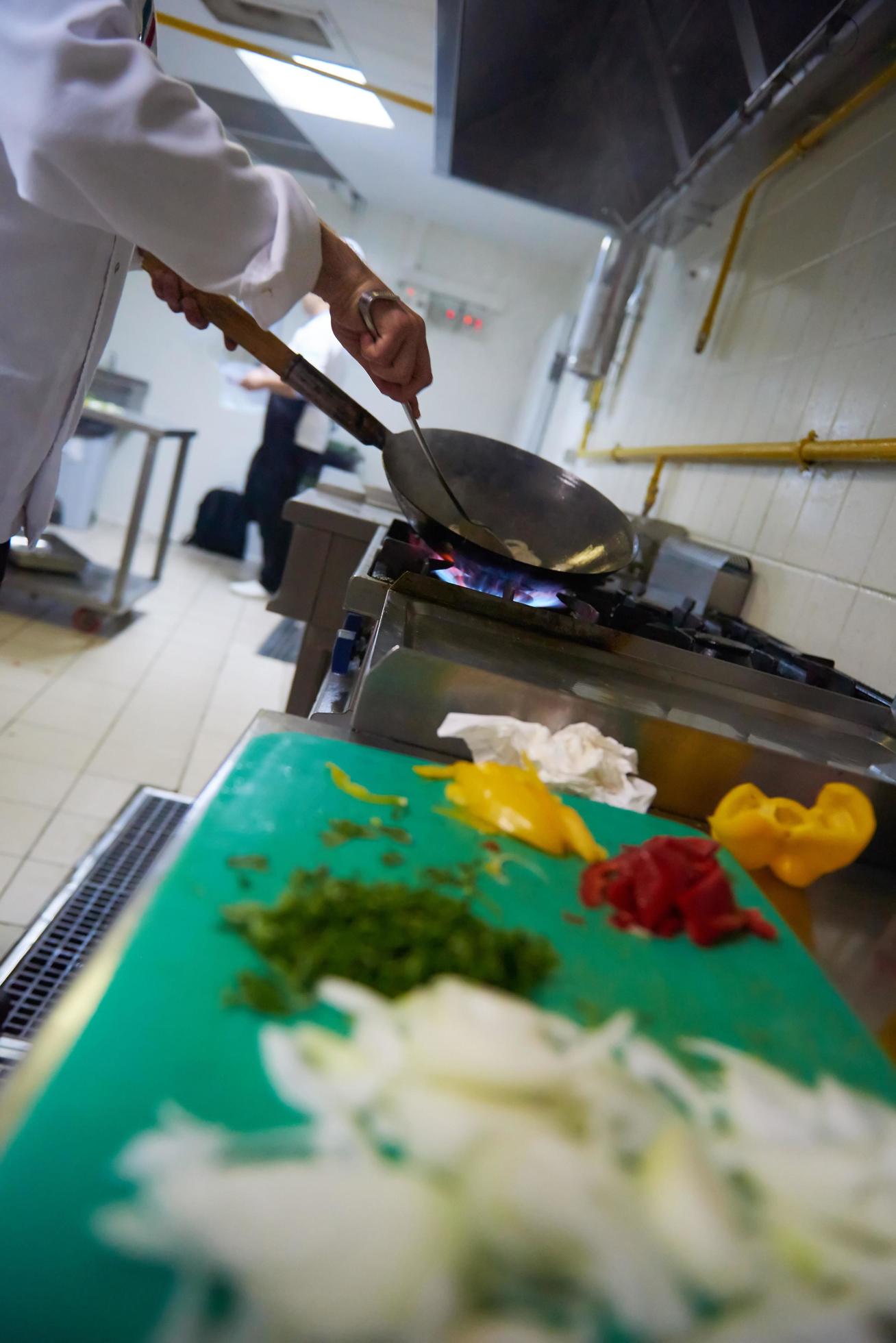 chef in hotel kitchen prepare food with fire Stock Free