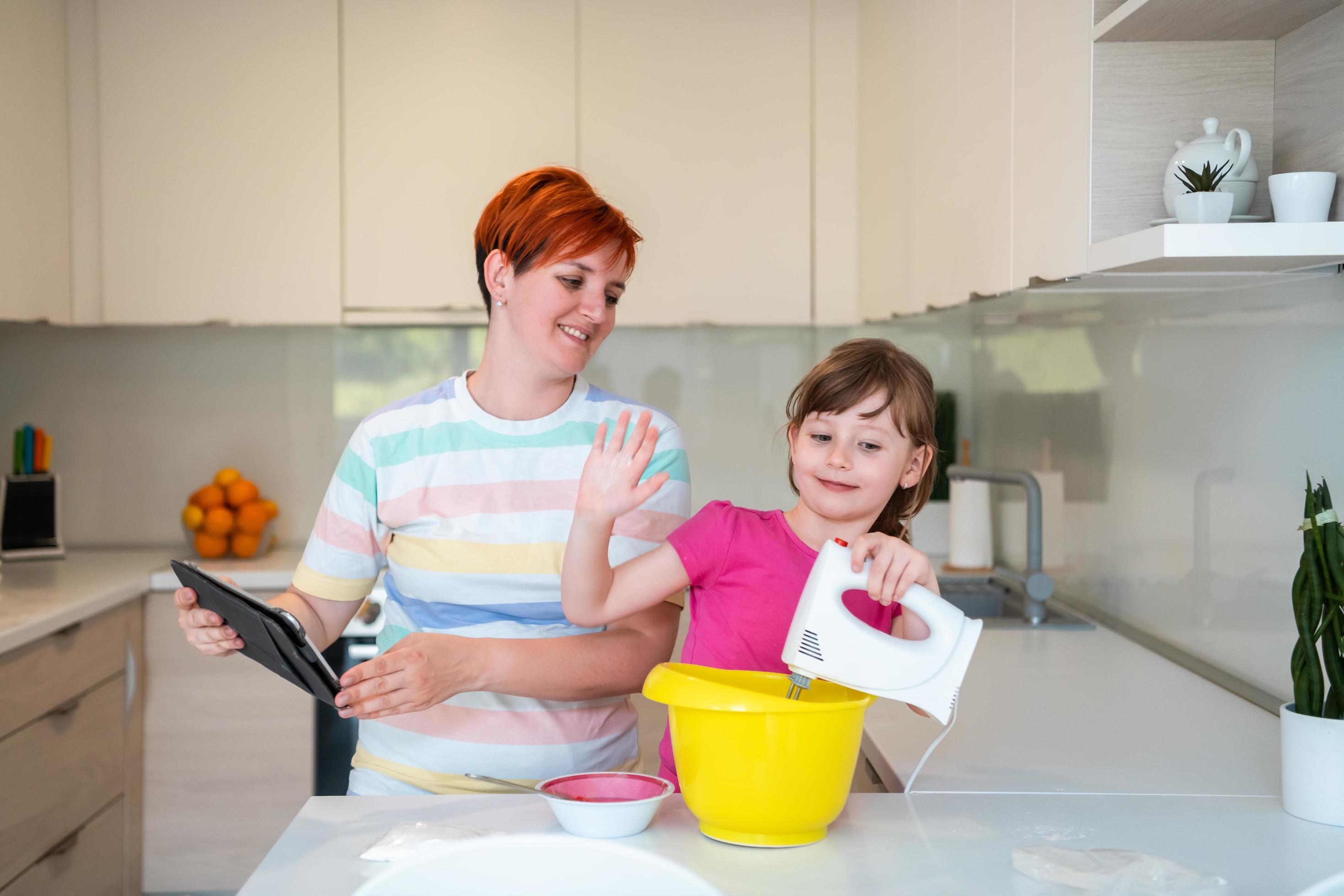 little girl and mom making tastz cake in kithen family having fun at home Stock Free