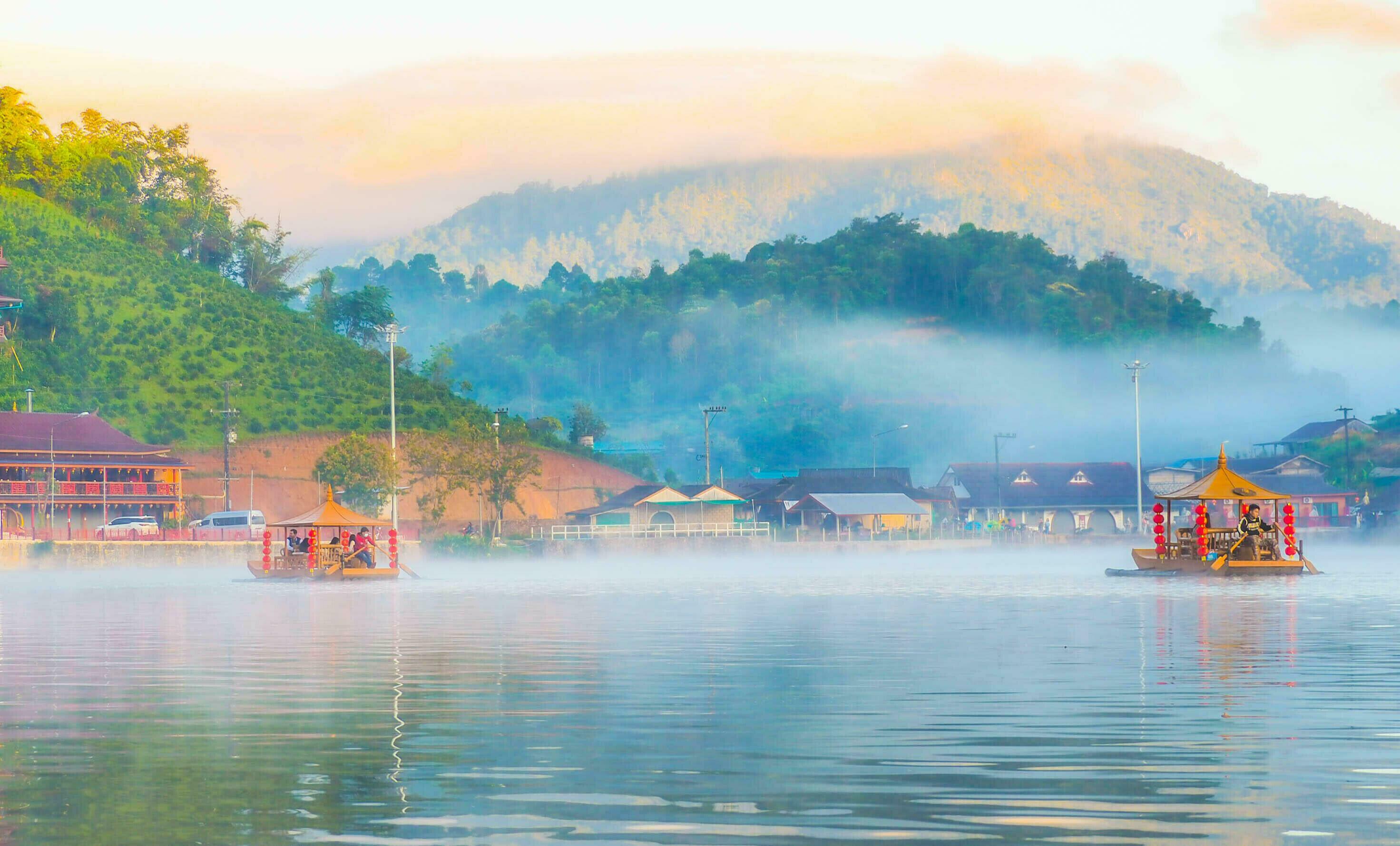 Chinese boat launched early in the morning at Rak Thai hamlet in Maehongson, Thailand, on the lake with water vapor, Banrakthai, Ban rak thai. Stock Free