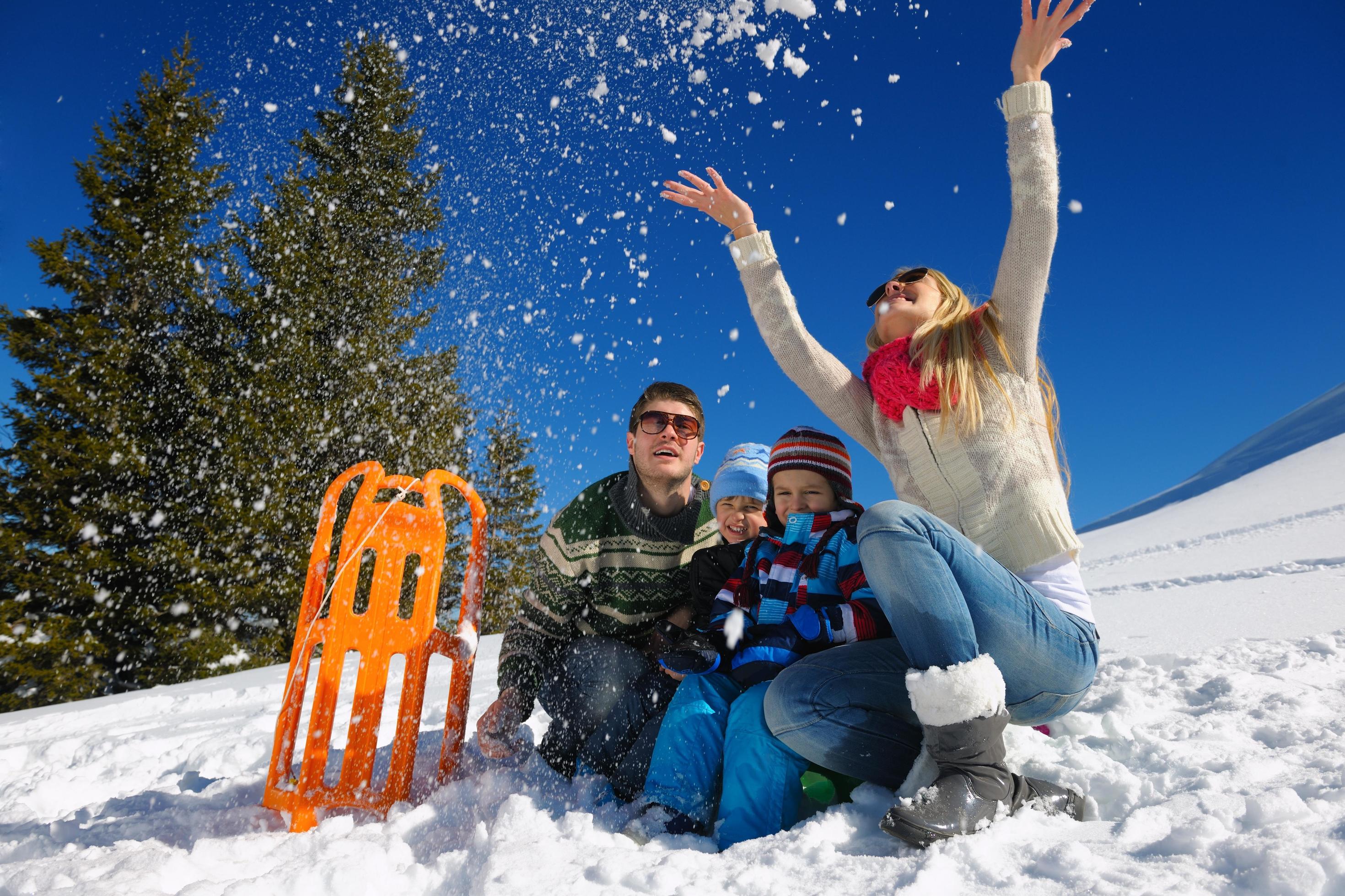 family having fun on fresh snow at winter vacation Stock Free