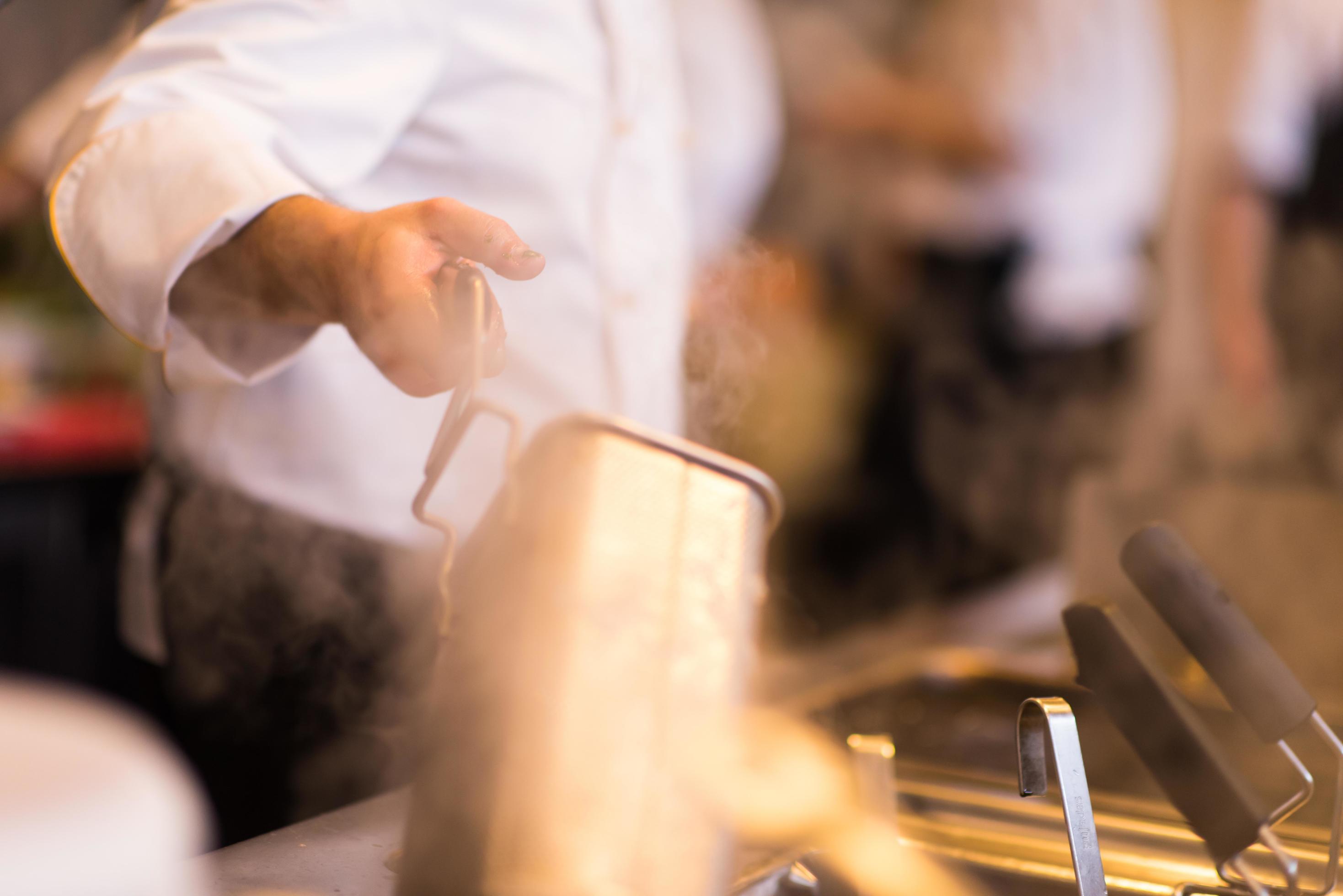 chef preparing food, frying in deep fryer Stock Free