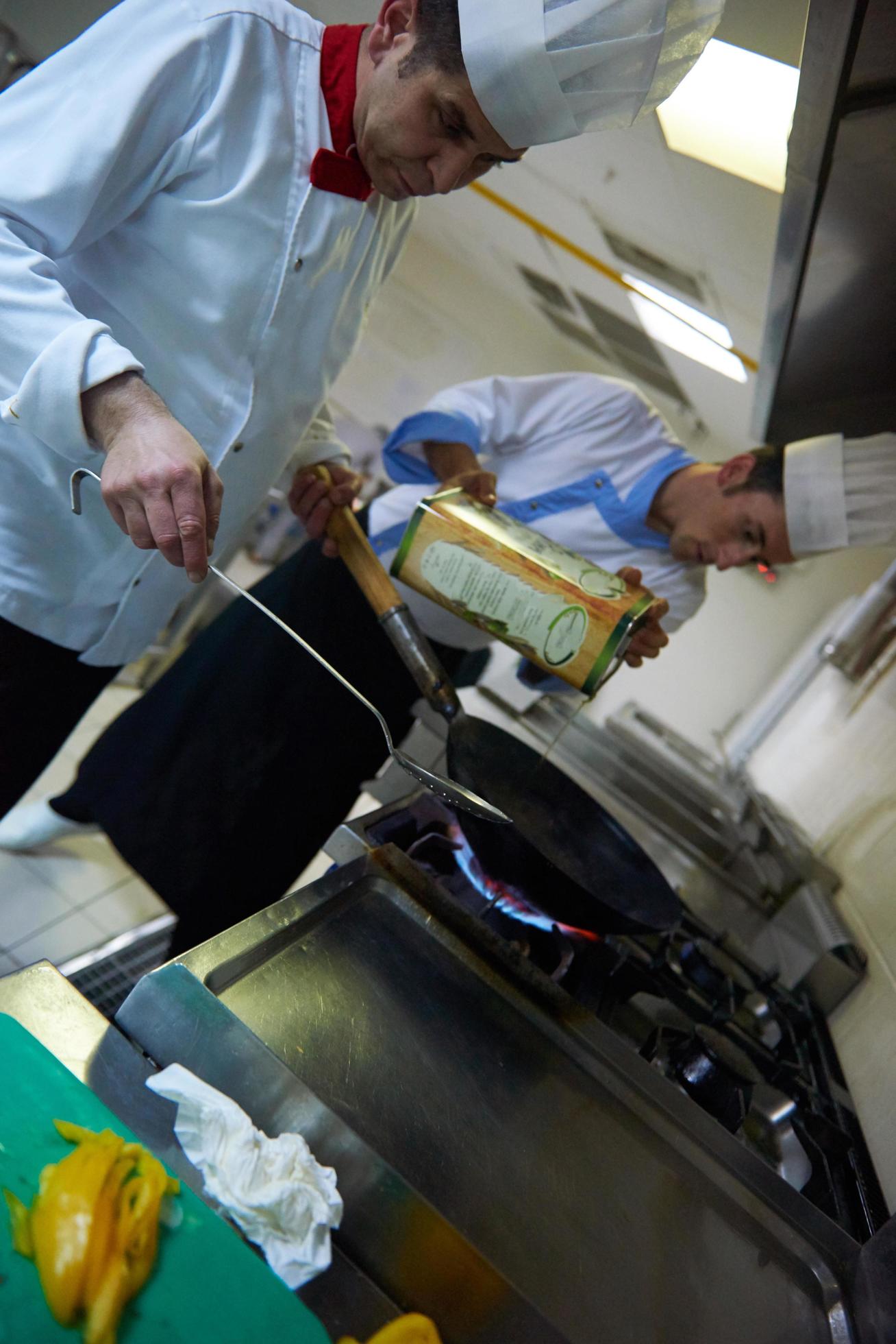 chef in hotel kitchen prepare food with fire Stock Free