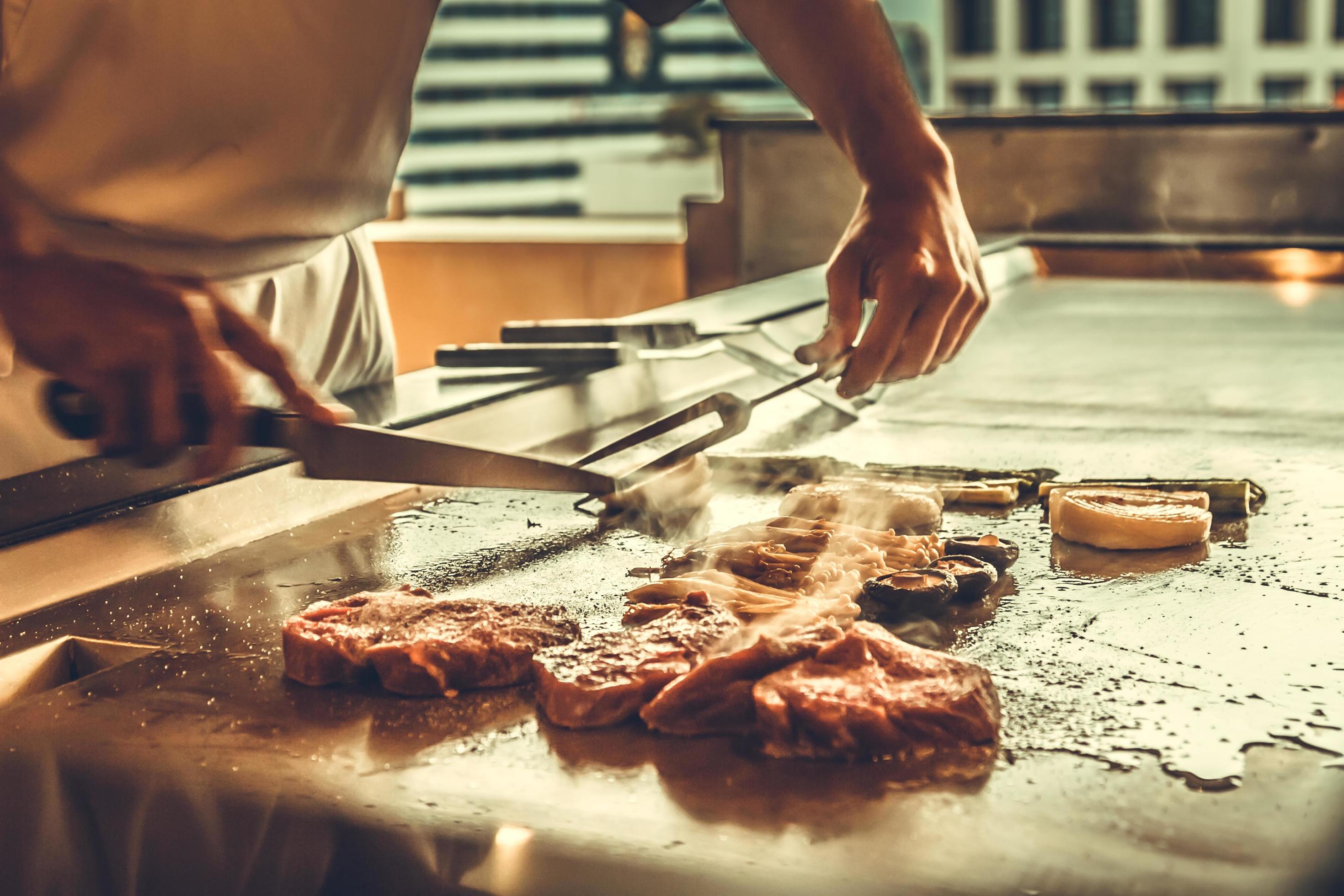 Close up hands chef cooking beef steak and vegetable on hot pan, Japanese food Stock Free