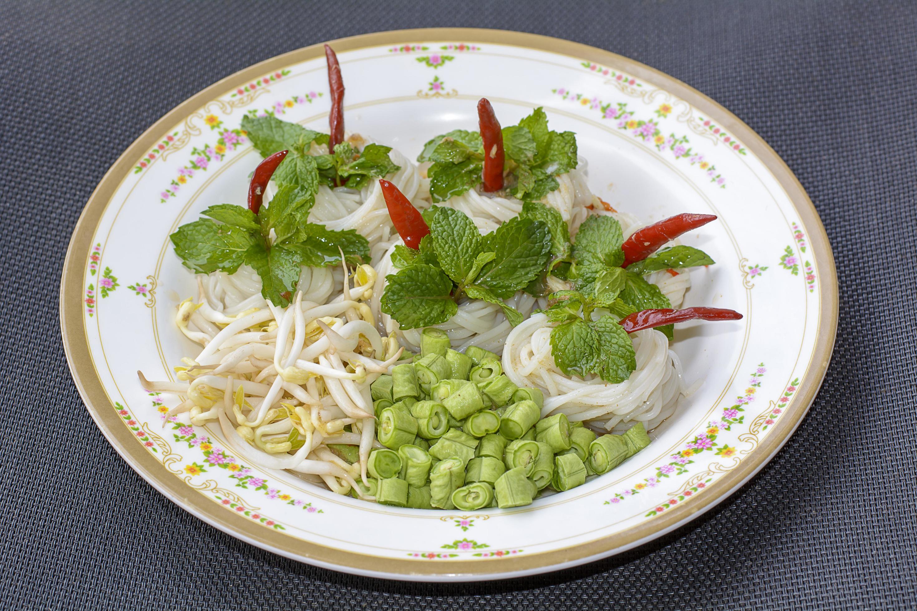 Rice noodles in fish curry sauce with vegetables or Thai vermicelli eaten with curry is Thai food. The dish is delicious and spicy food. Stock Free