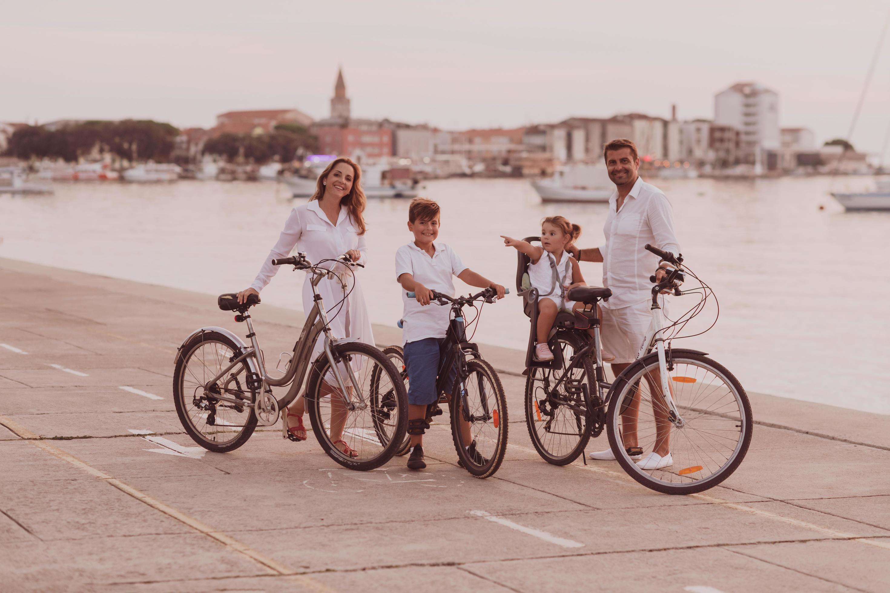 The happy family enjoys a beautiful morning by the sea riding a bike together and spending time together. The concept of a happy family Stock Free