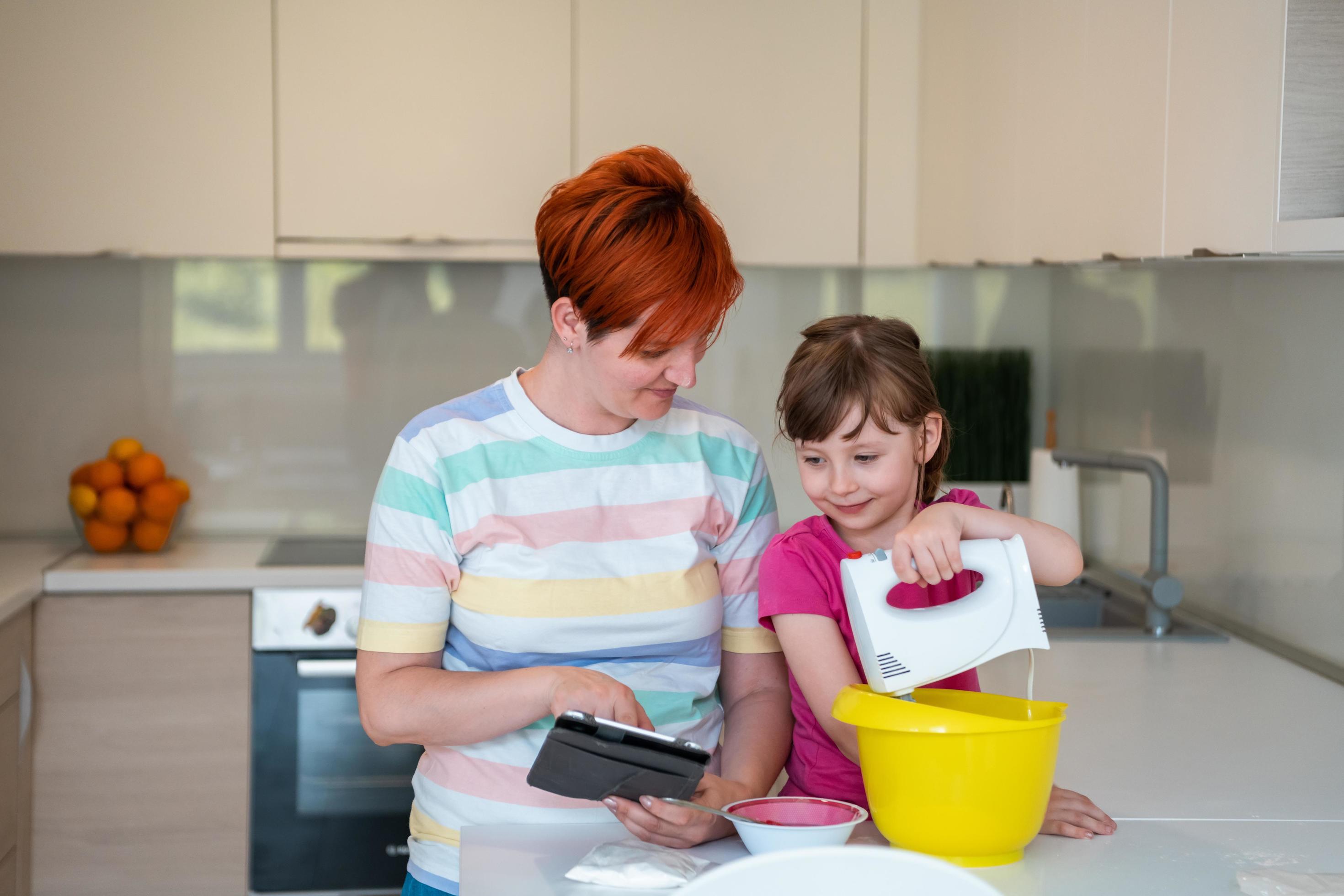 little girl and mom making tastz cake in kithen family having fun at home Stock Free