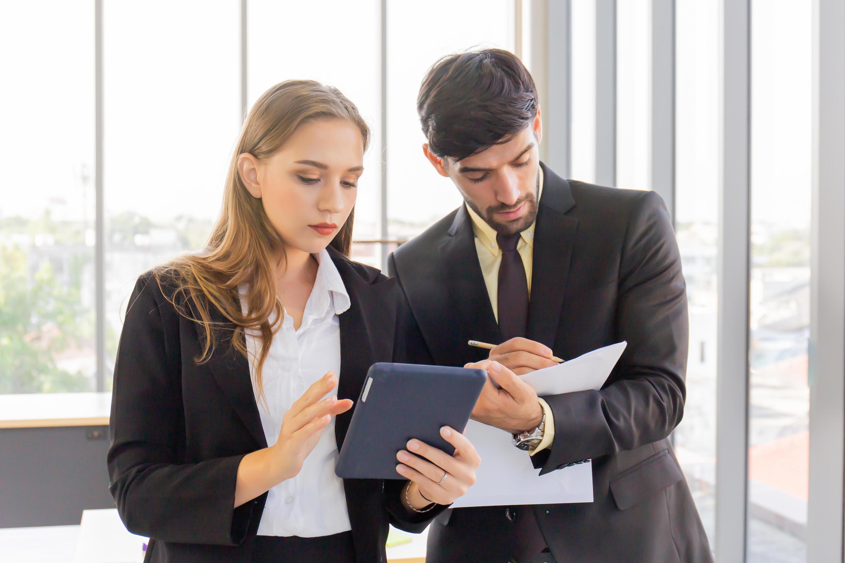 Two business men and women standing meeting in the office Stock Free