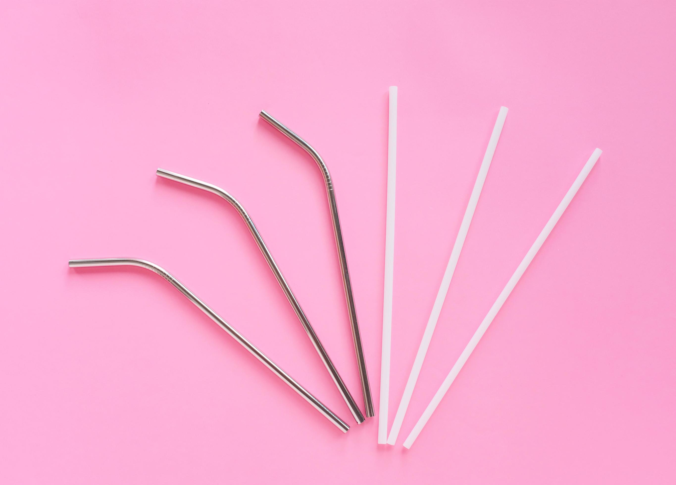 Flat lay of reusable stainless steel straw with plastic straw on bright pink color background, sustainable lifestyle and zero waste concept Stock Free