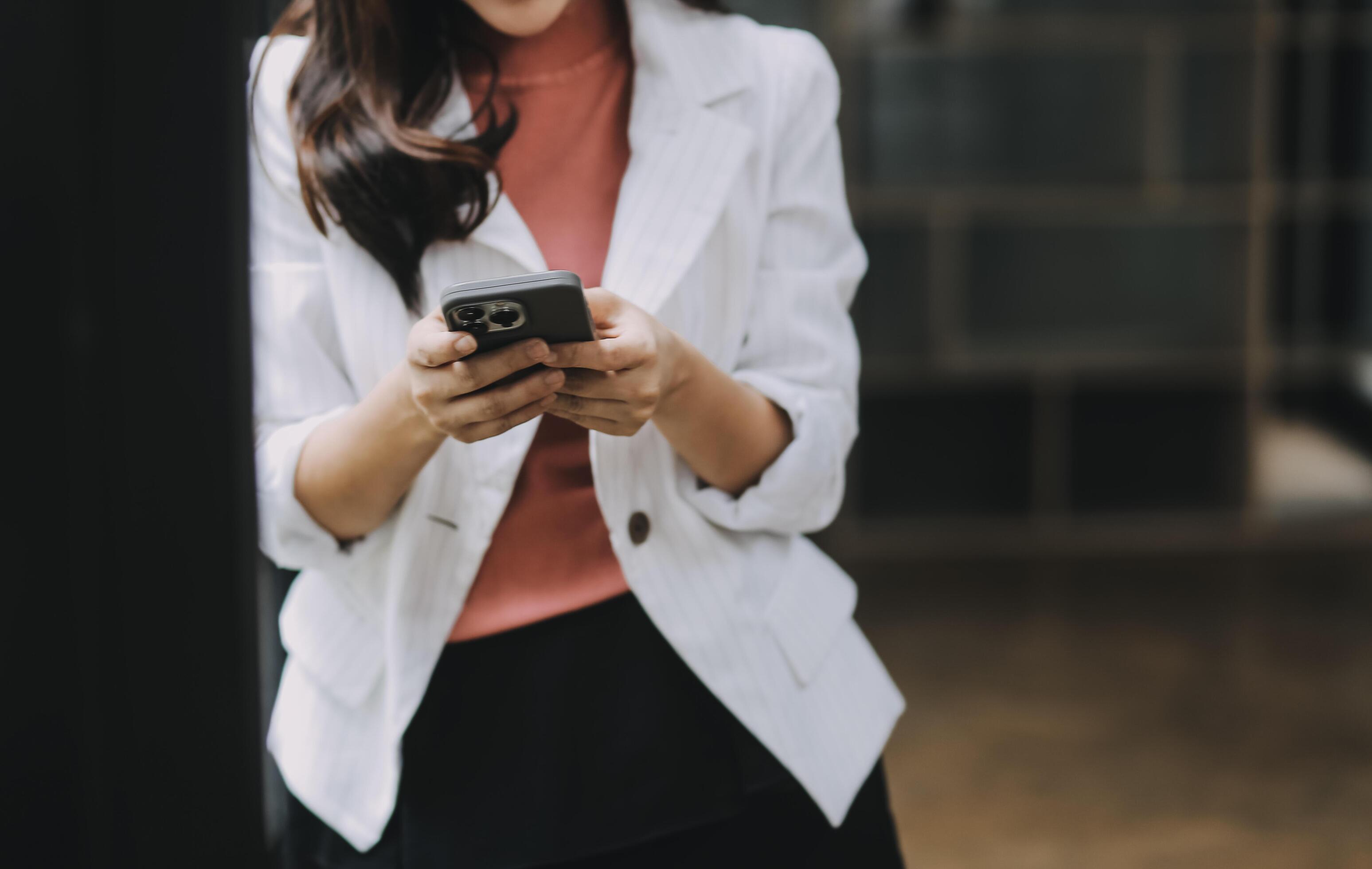 Portrait of a happy Asian businesswoman using mobile phone indoor, Asian businesswoman working in modern office. Stock Free