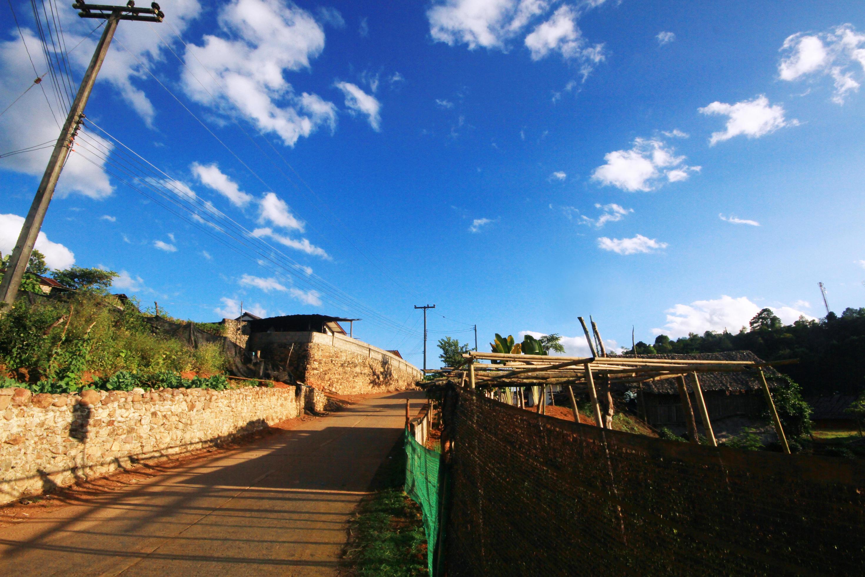 Yunnan Chinese hilltribe houses on the mountain with beautiful blue sky and sunlight in northern Thailand Stock Free