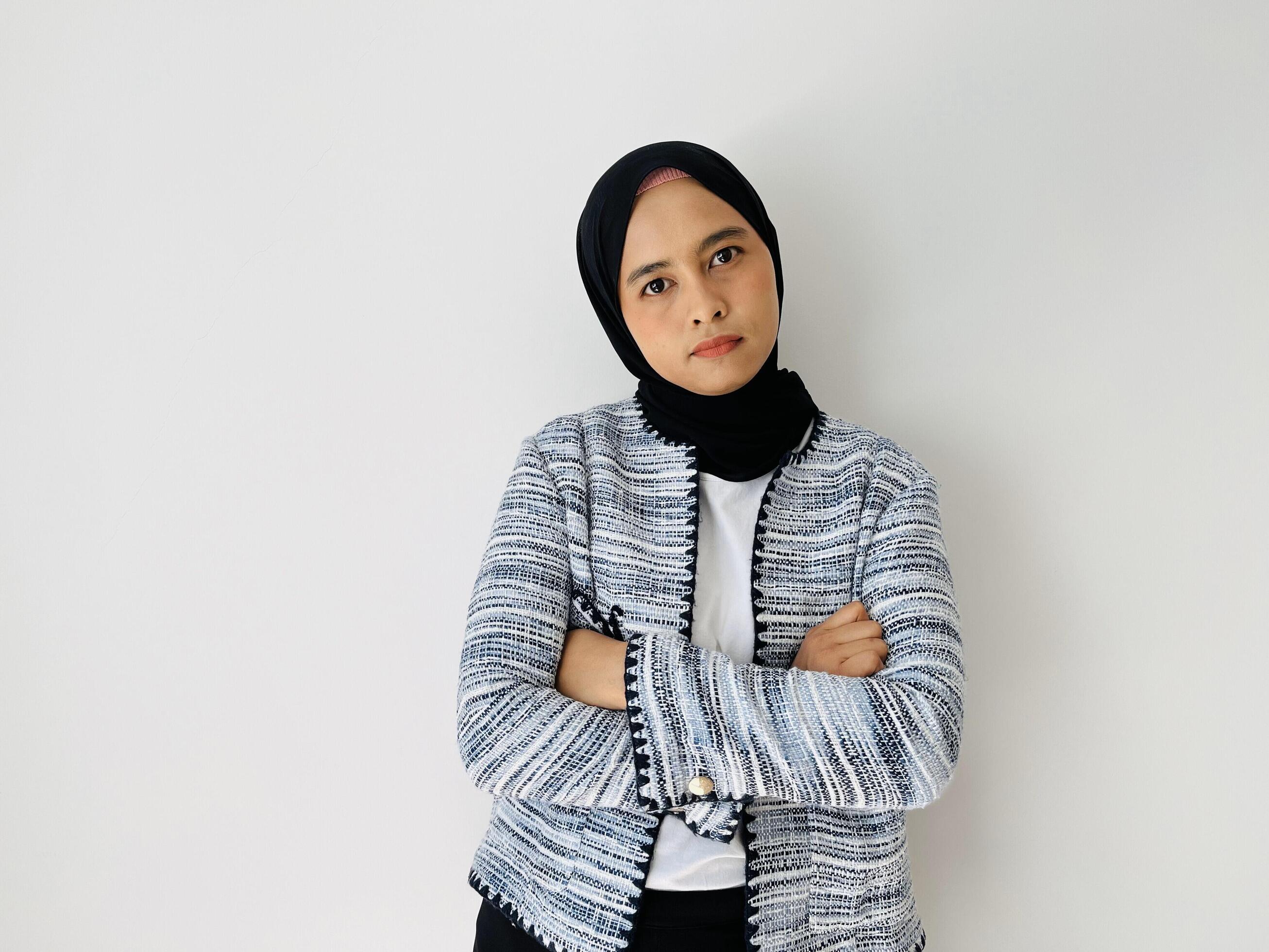 A serious face young Asian Muslim woman crossed arms and looking confident isolated over white background Stock Free