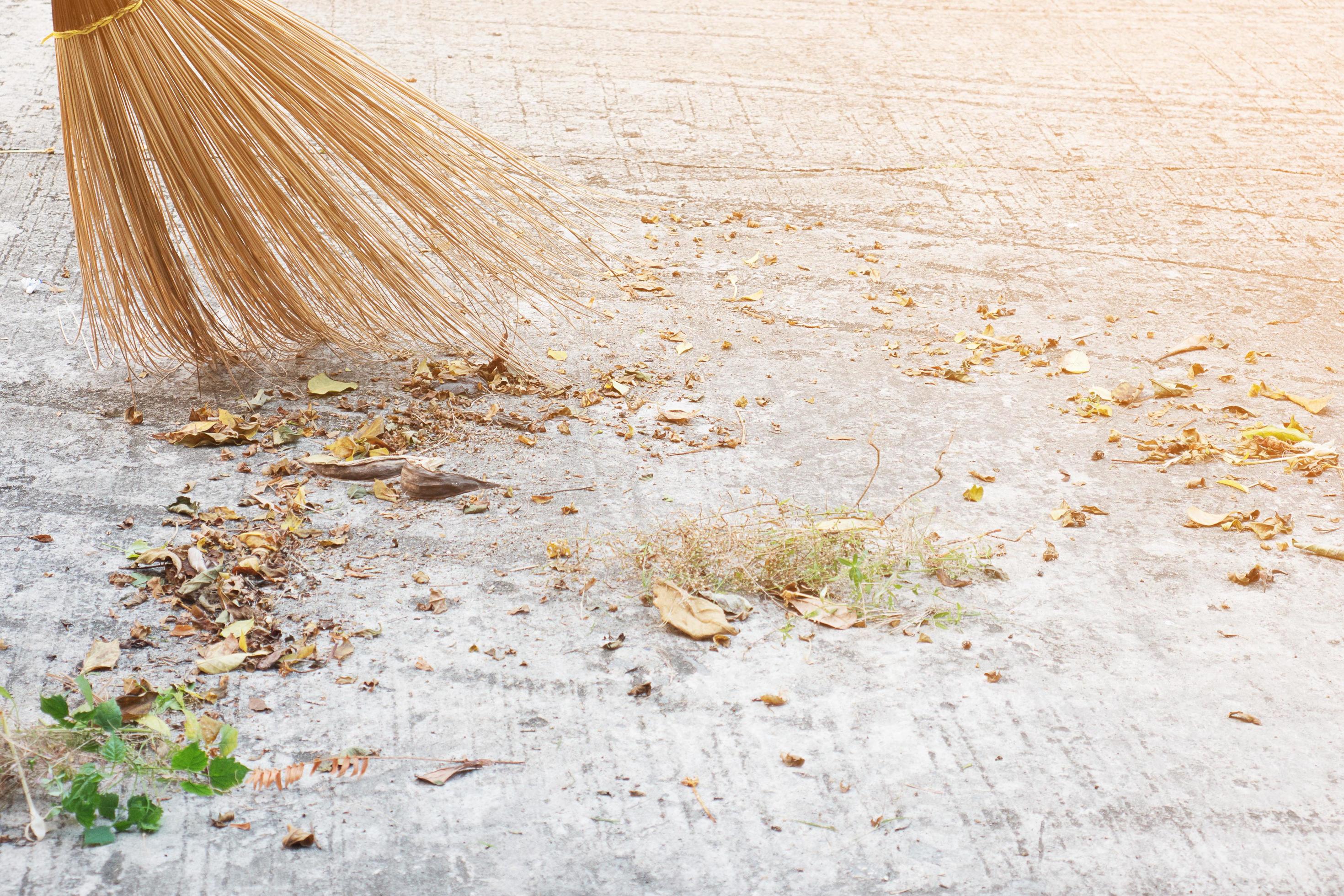 Man cleaning outdoor road using bloom made from dry coconut leave product – local people lifestyle concept in Thailand Stock Free