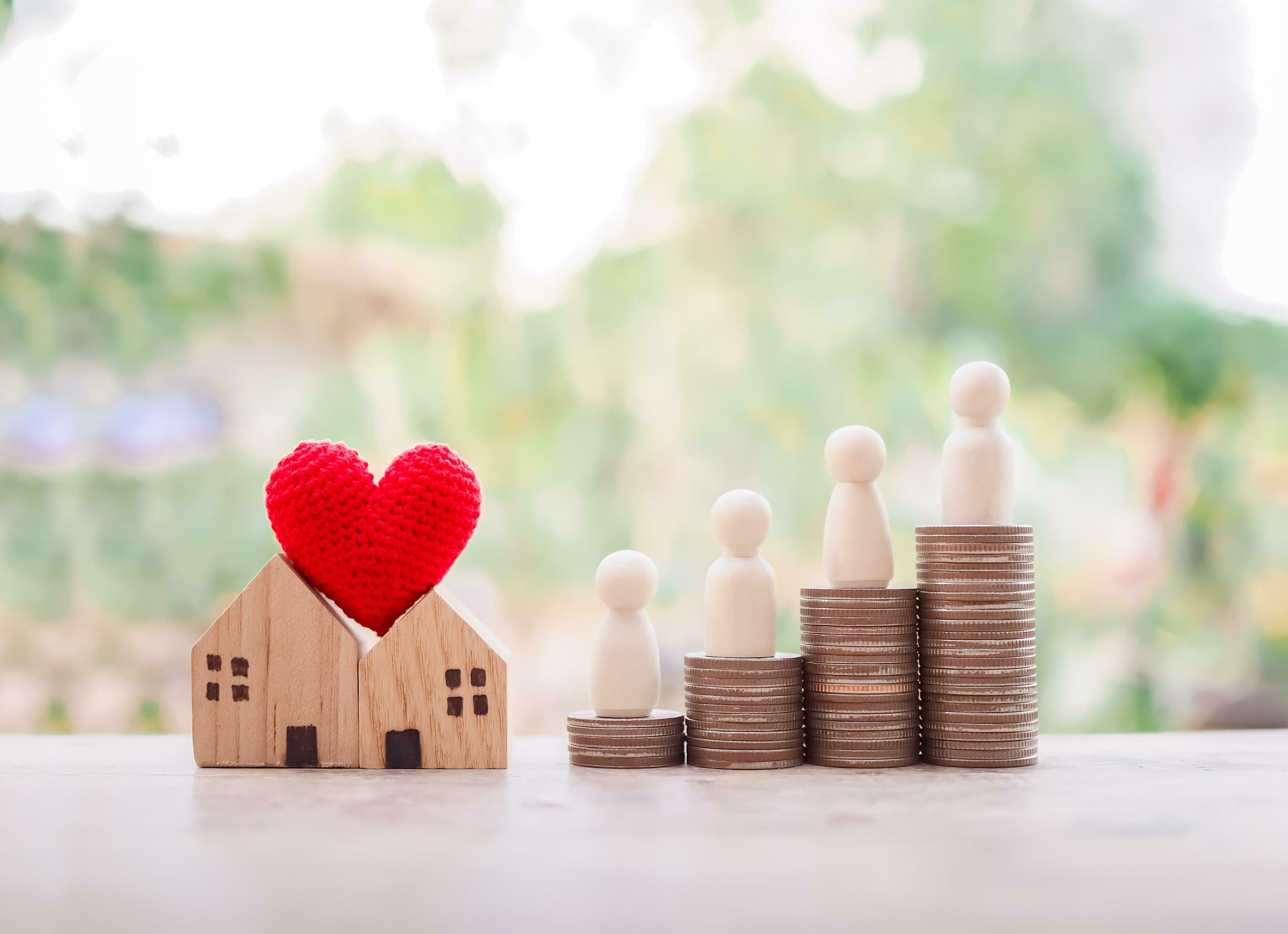 Wooden figure of the family on stack of coins and miniature house for Investment property concept. Saving money for buy a house. Stock Free