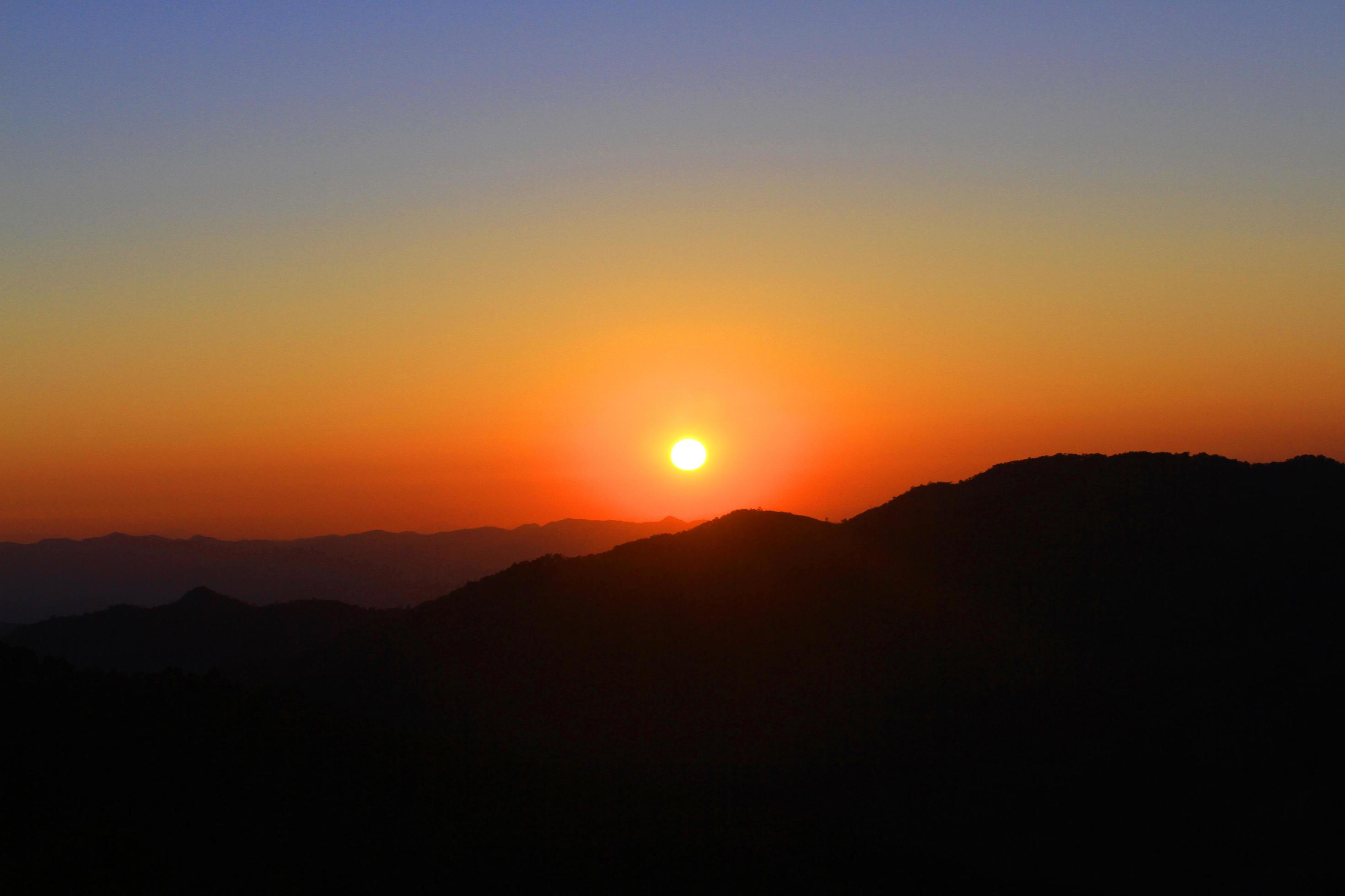 Sunset in sky and cloud, beautiful colorful twilight time with silhouette of mountain. Stock Free