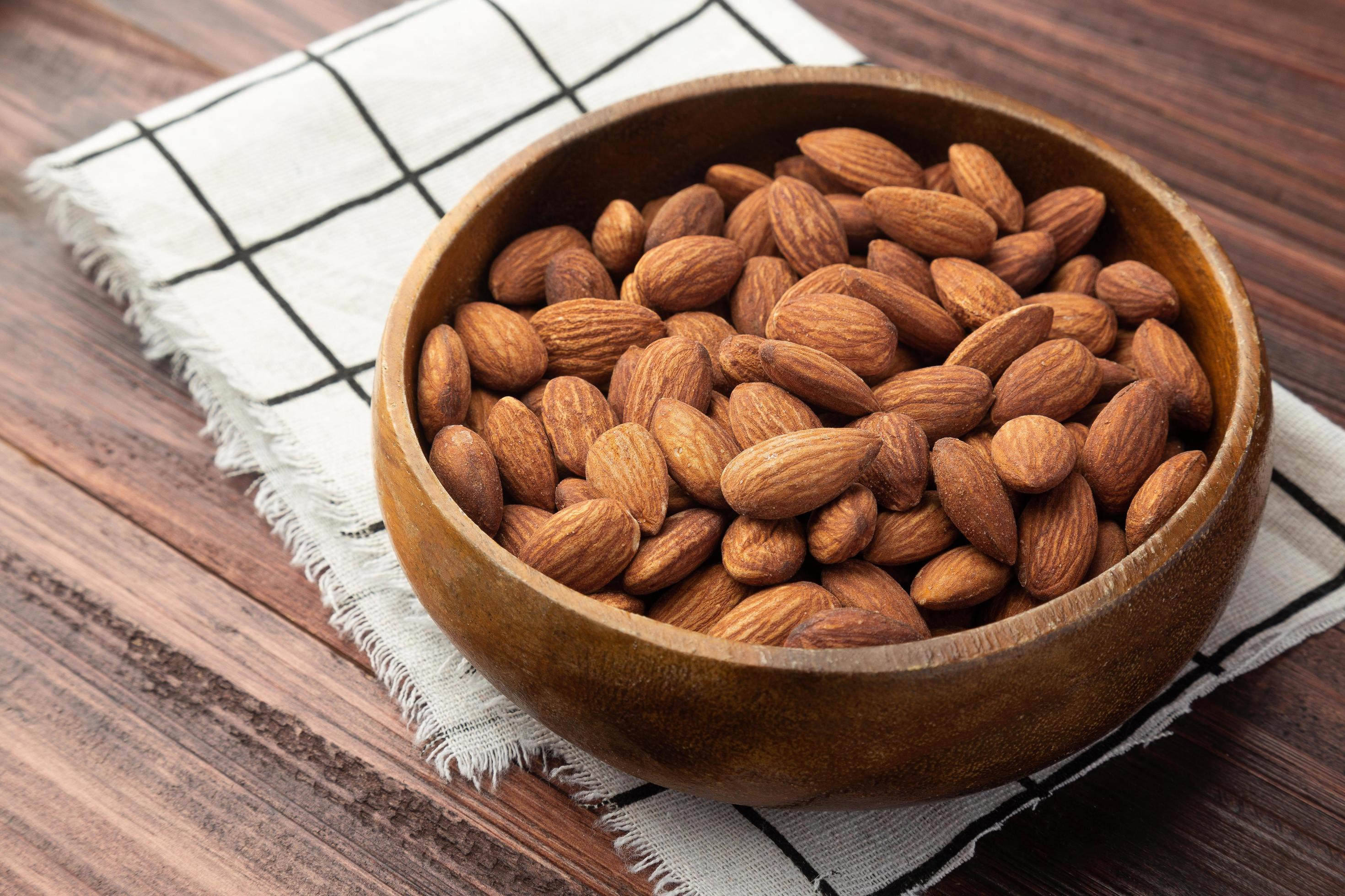 Almonds in wooden bowl on the table, Healthy snack, Vegetarian food Stock Free