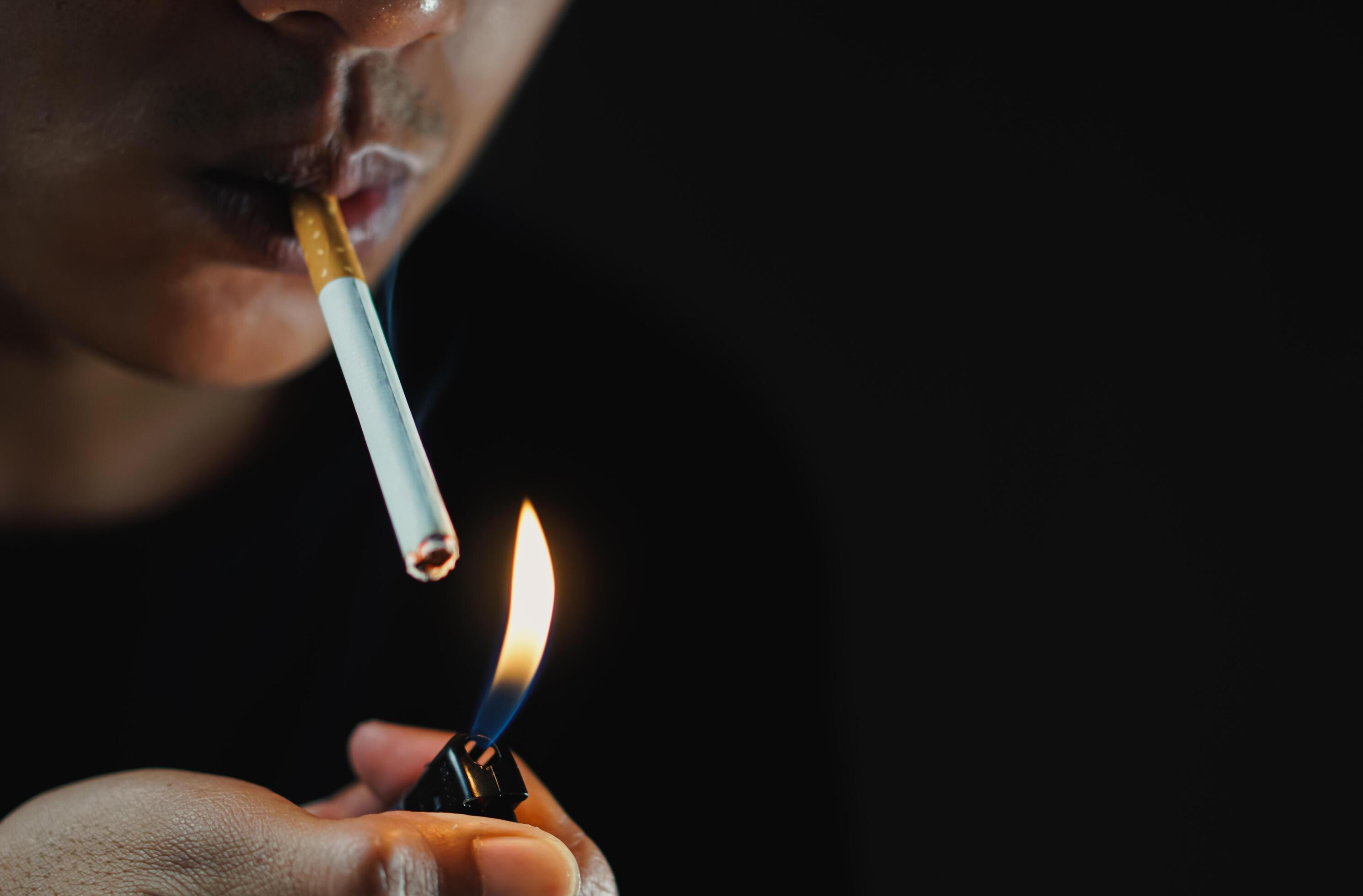 A man smoking cigarette in dark room Stock Free