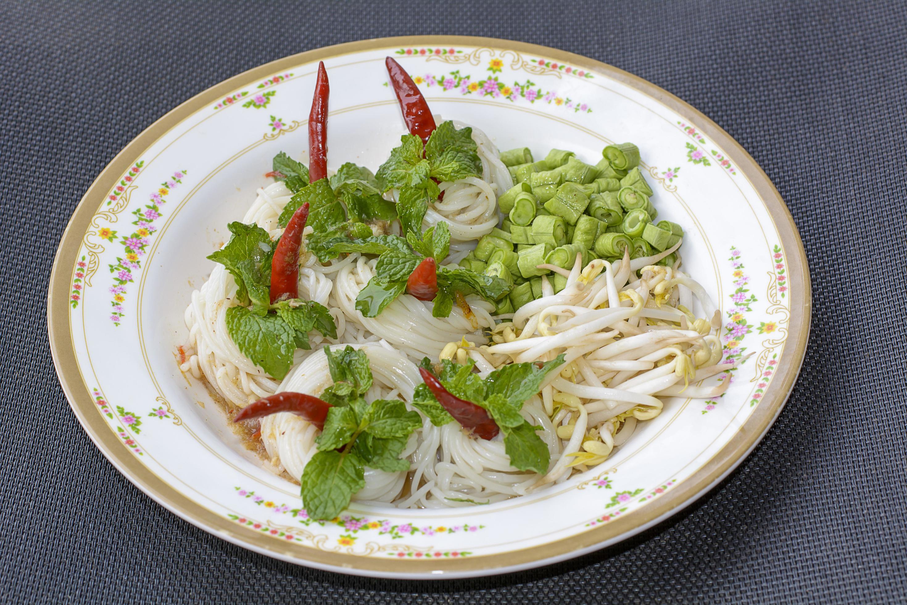 Rice noodles in fish curry sauce with vegetables or Thai vermicelli eaten with curry is Thai food. The dish is delicious and spicy food. Stock Free