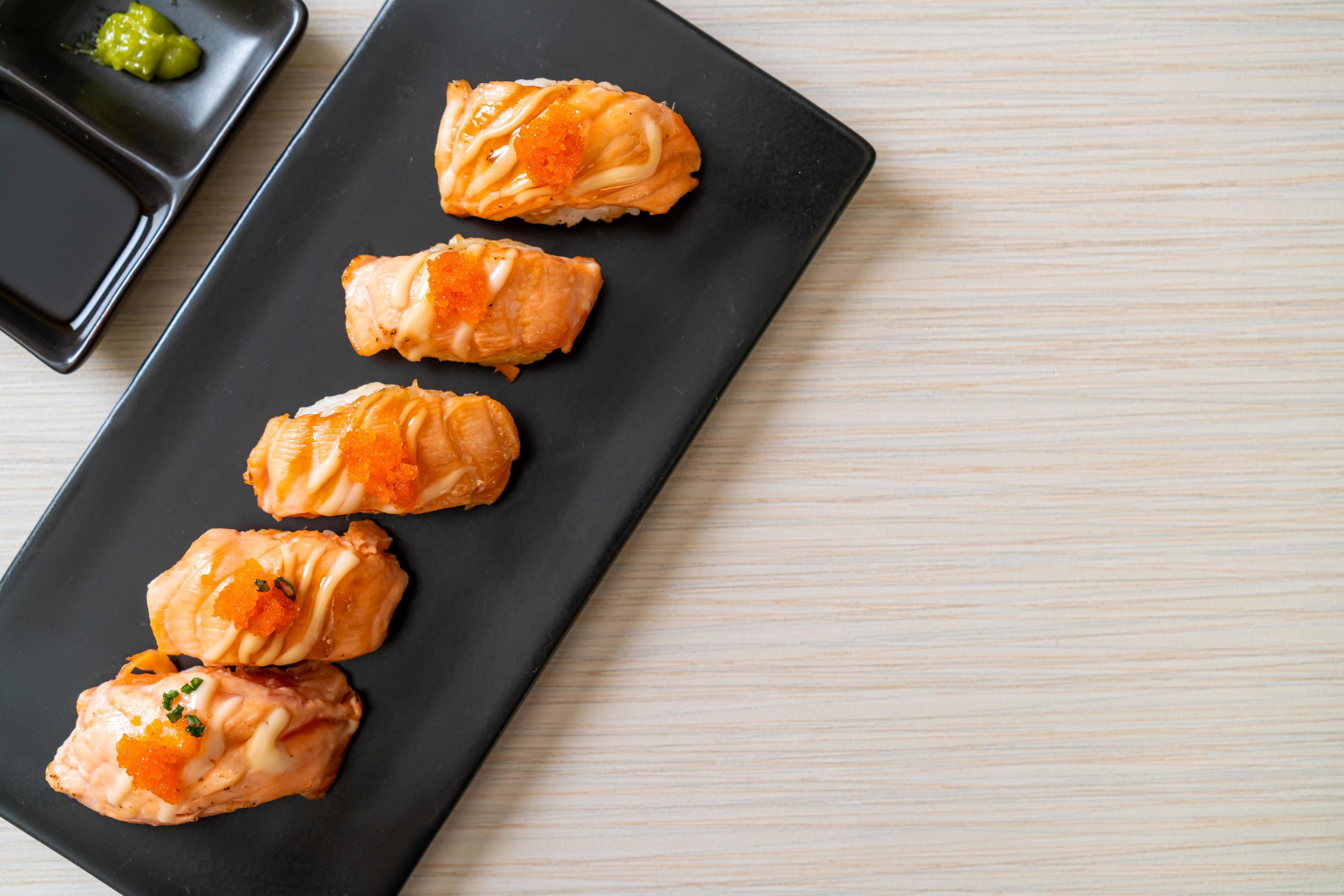 Grilled salmon sushi on black plate – Japanese food style Stock Free