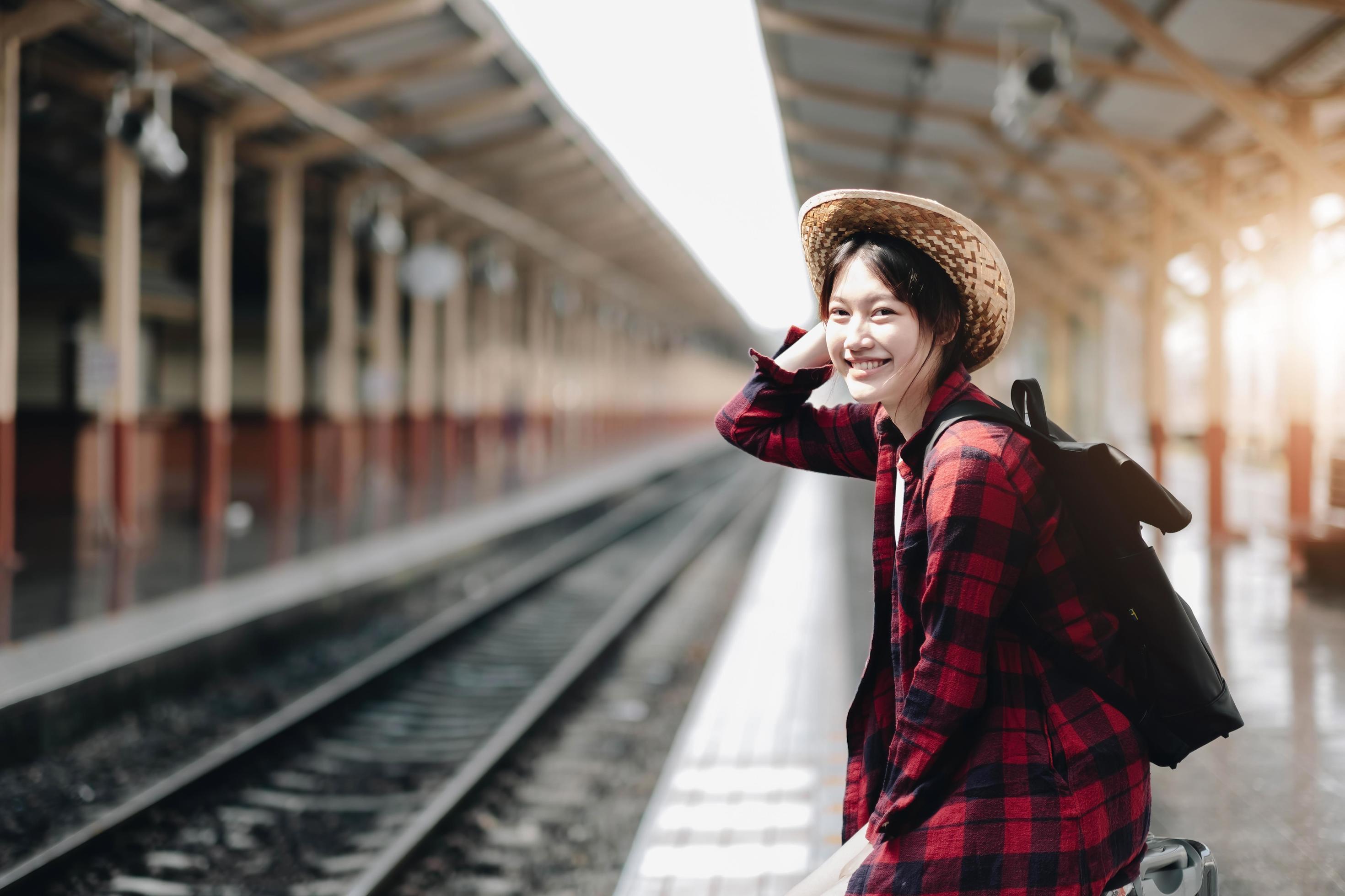 Young traveler woman looking for friend planning trip at train station. Summer and travel lifestyle concept Stock Free