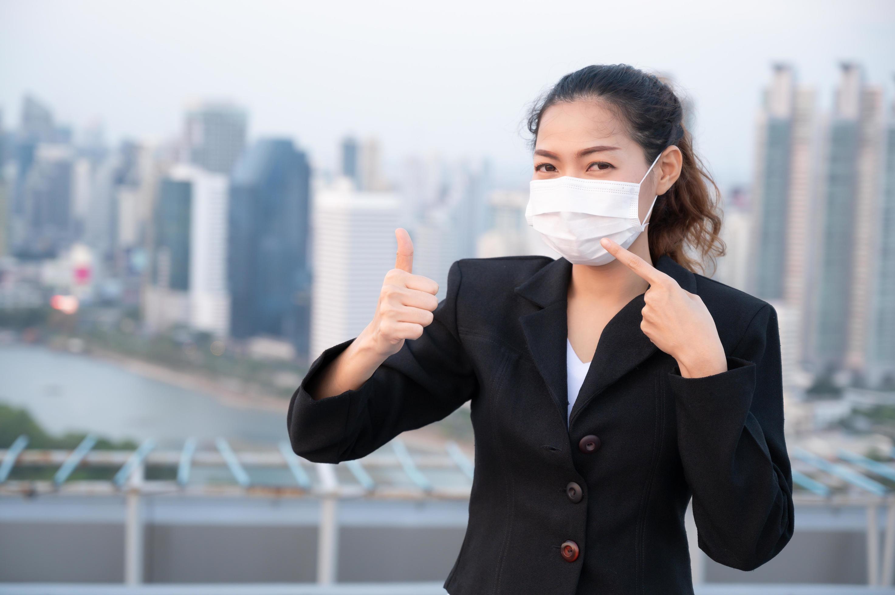 Asian business women have to use a mask to cover the face to prevent pollution from dust Stock Free