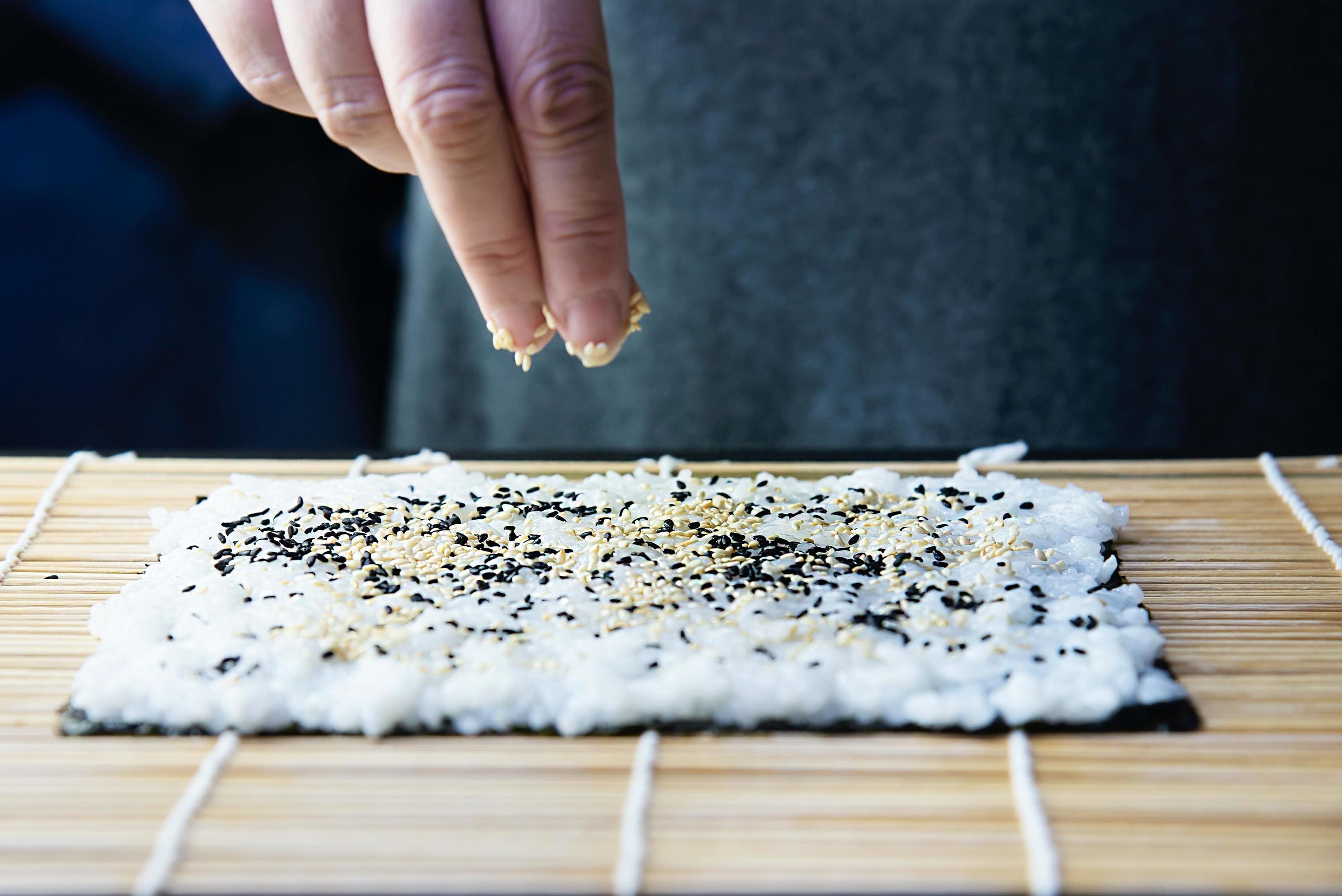 Chef preparing sushi roll over black table background – people with favorite dish Japanese food concept Stock Free