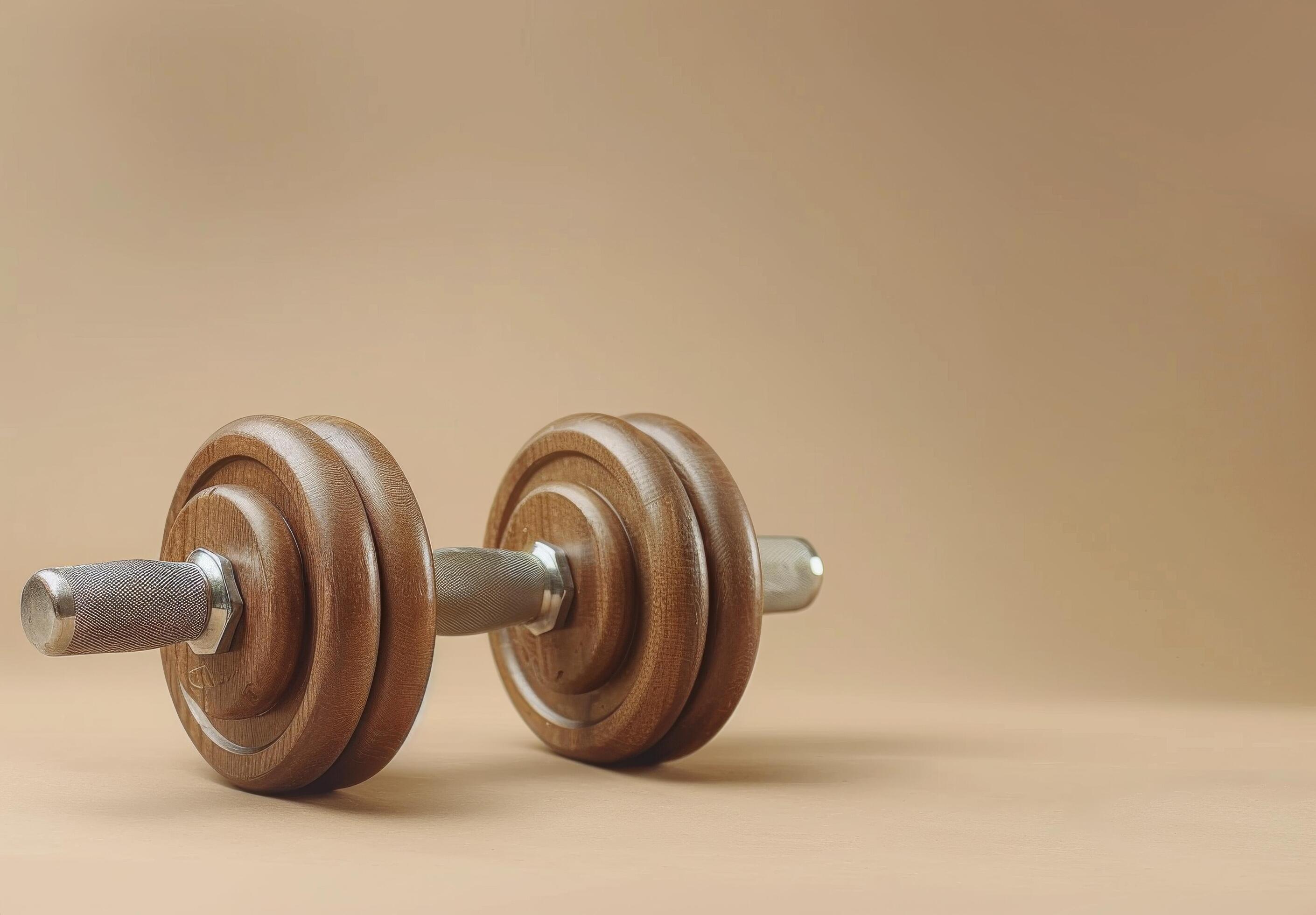 Single Black Dumbbell On A Beige Background Stock Free