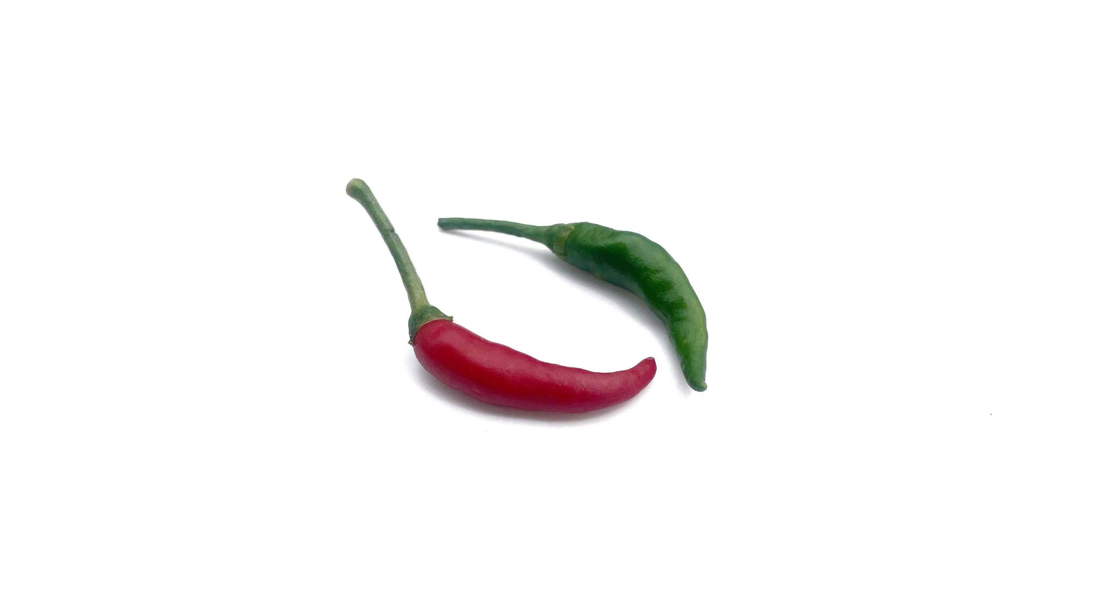 Fresh red and green chili peppers placed on a white background, great for editing and advertising spicy foods. Stock Free