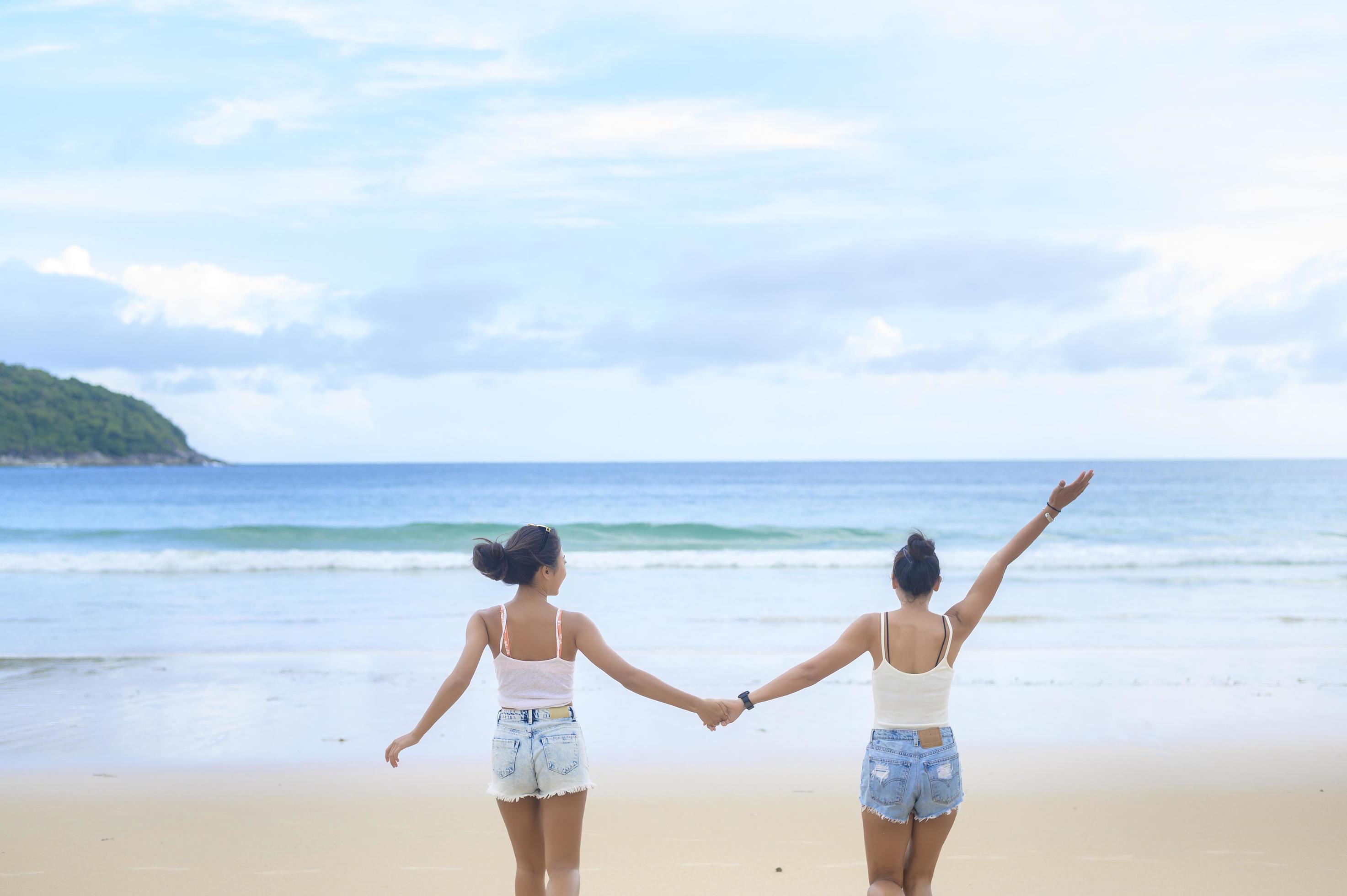 Two attractive women friends enjoying and relaxing on the beach, Summer, vacation, holidays, Lifestyles concept. Stock Free