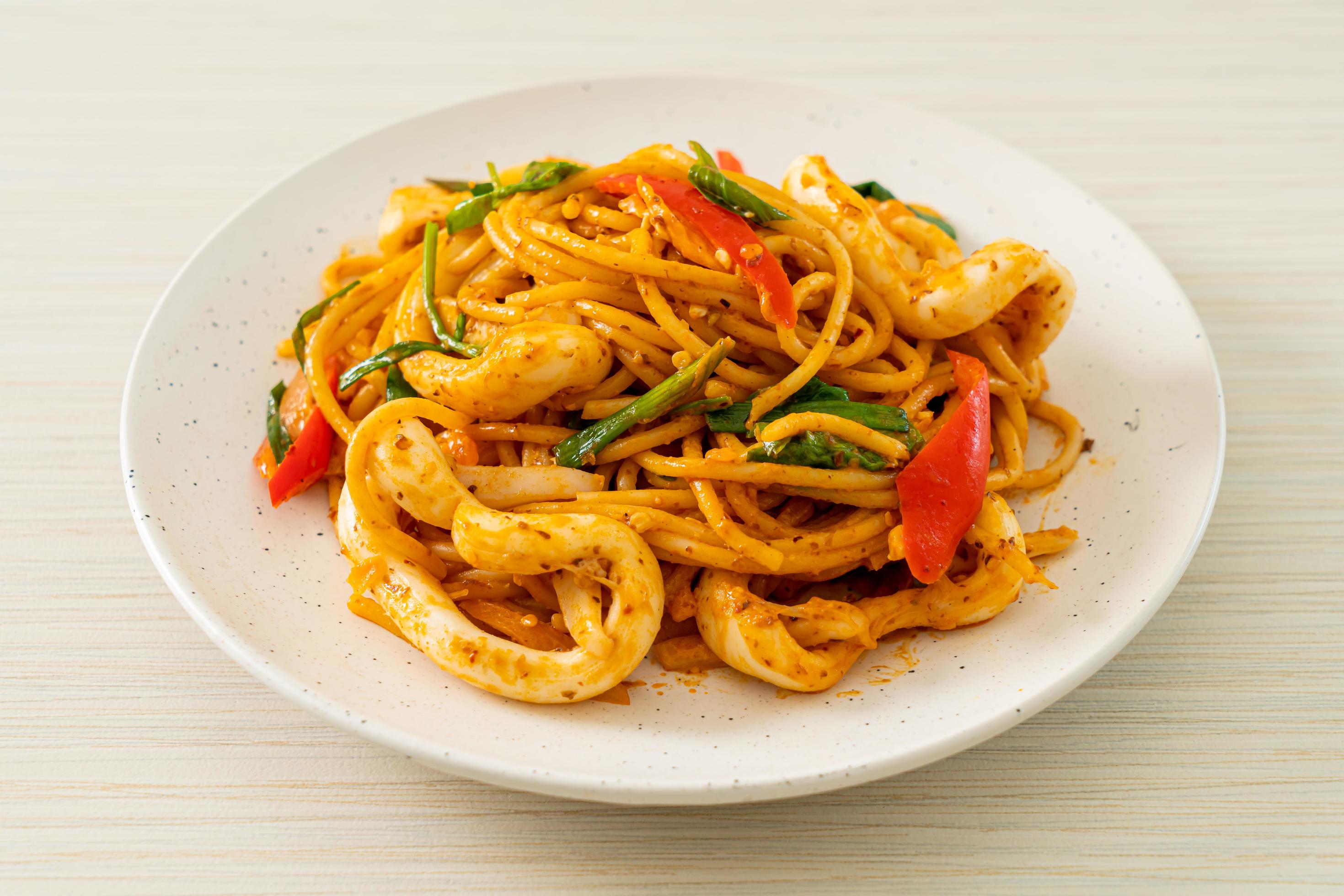 Stir-fried spaghetti with salted egg and squid – fusion food style Stock Free