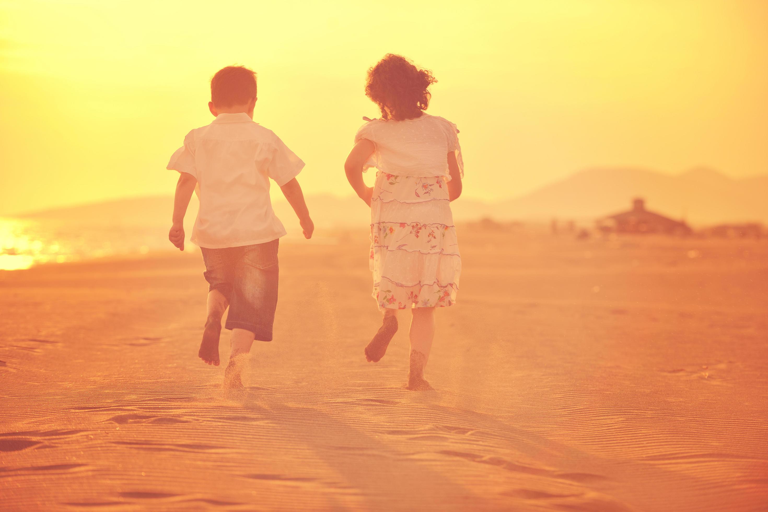 happy young family have fun on beach at sunset Stock Free