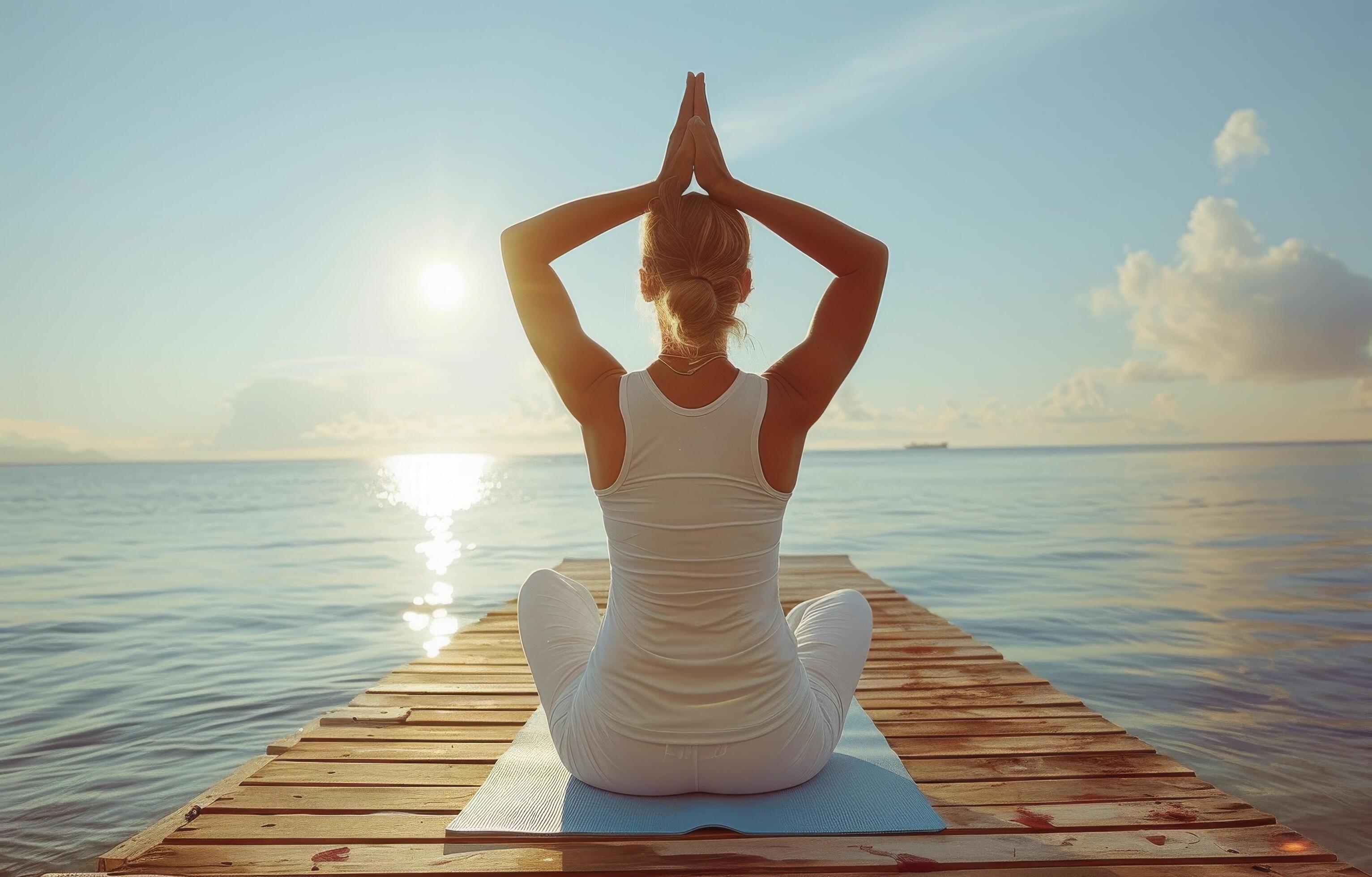 Woman Practicing Yoga on Wooden Dock During Sunrise at the Beach Stock Free