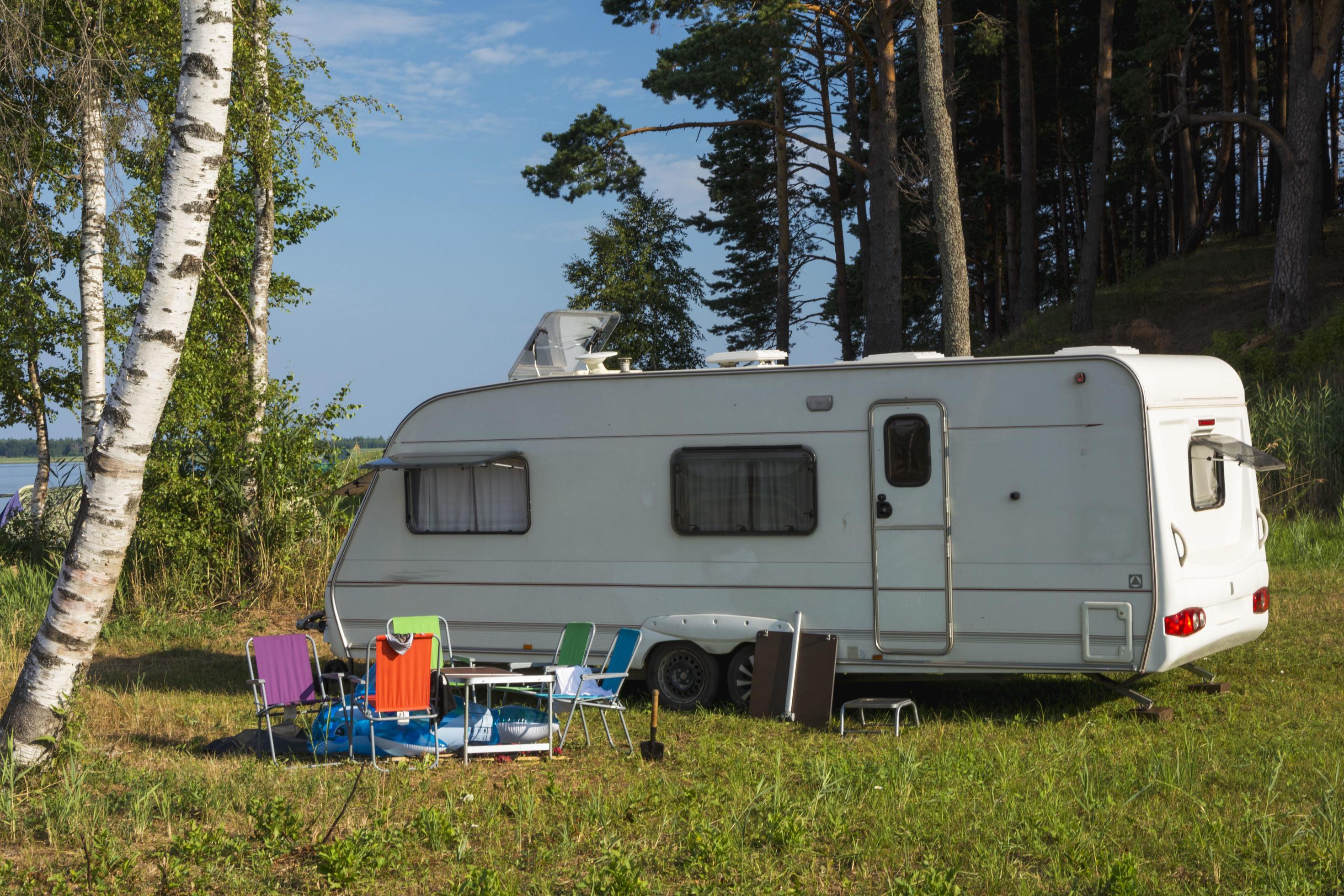 Camper trailer in nature on the background of the lake, tourism, travel, outdoor recreation, active lifestyle Stock Free