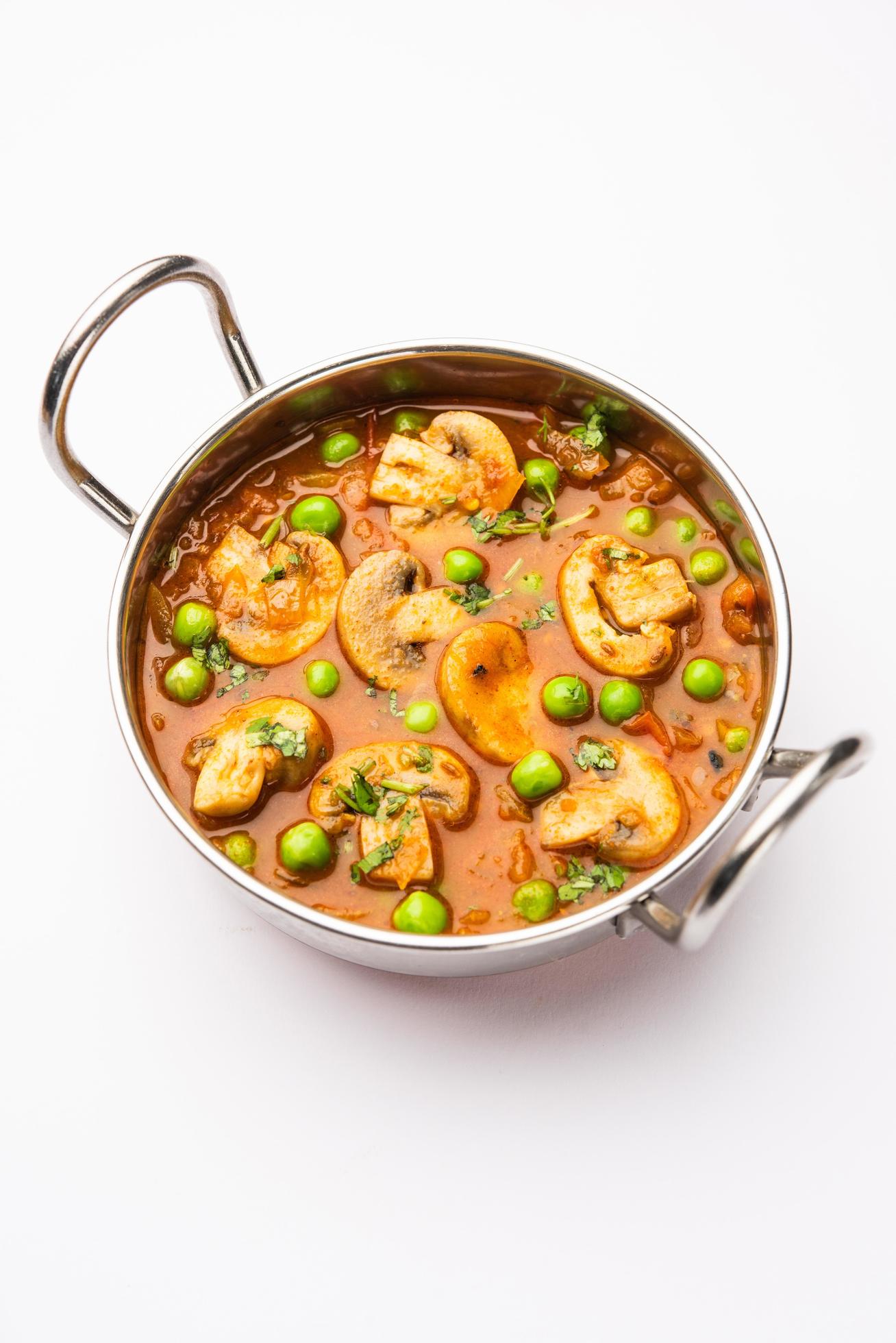 Mushroom and Pea Curry with Roasted Garlic, Indian food served in a bowl Stock Free