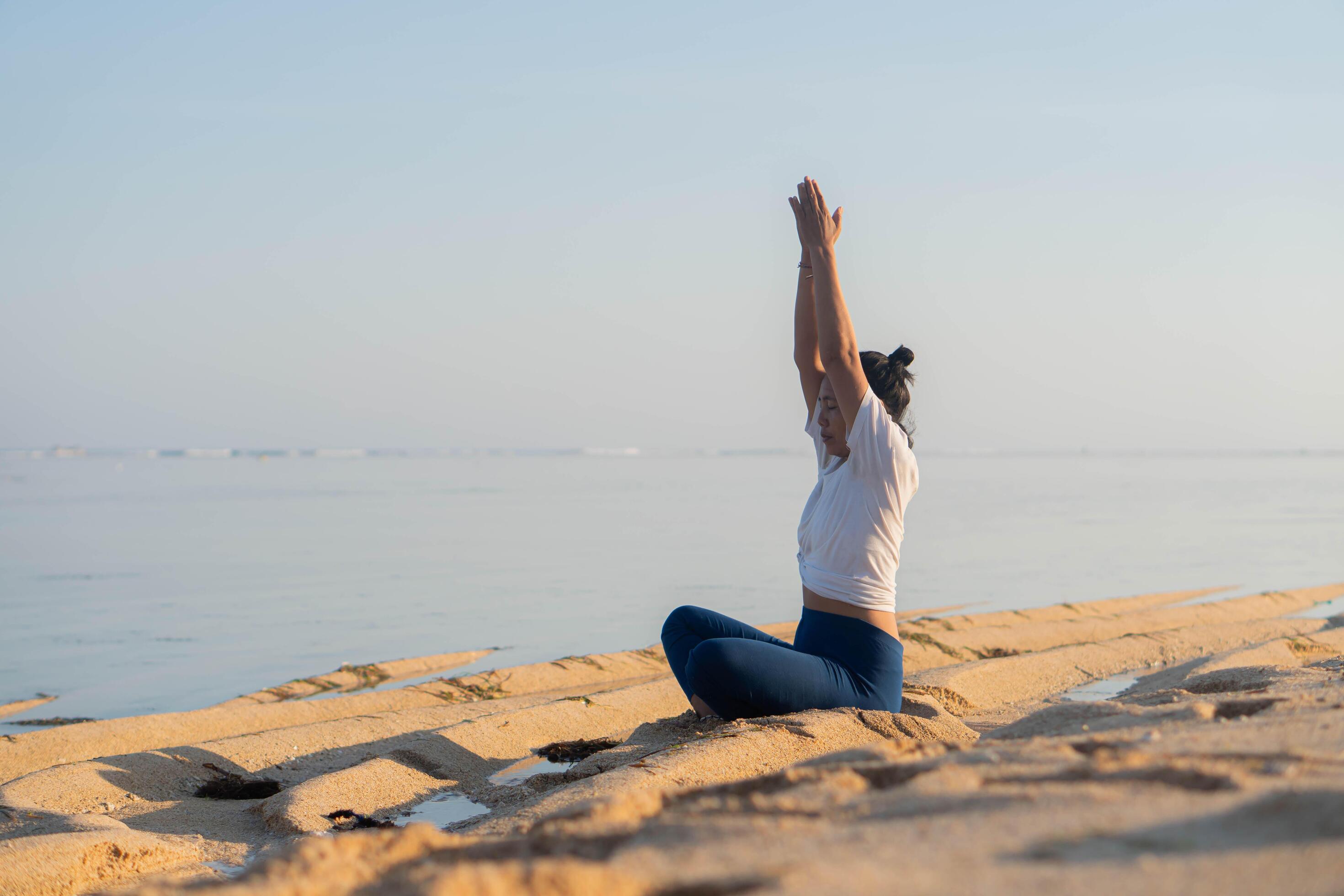 healthy woman with beautiful body doing yoga at sunrise on the beach, yoga poses Stock Free