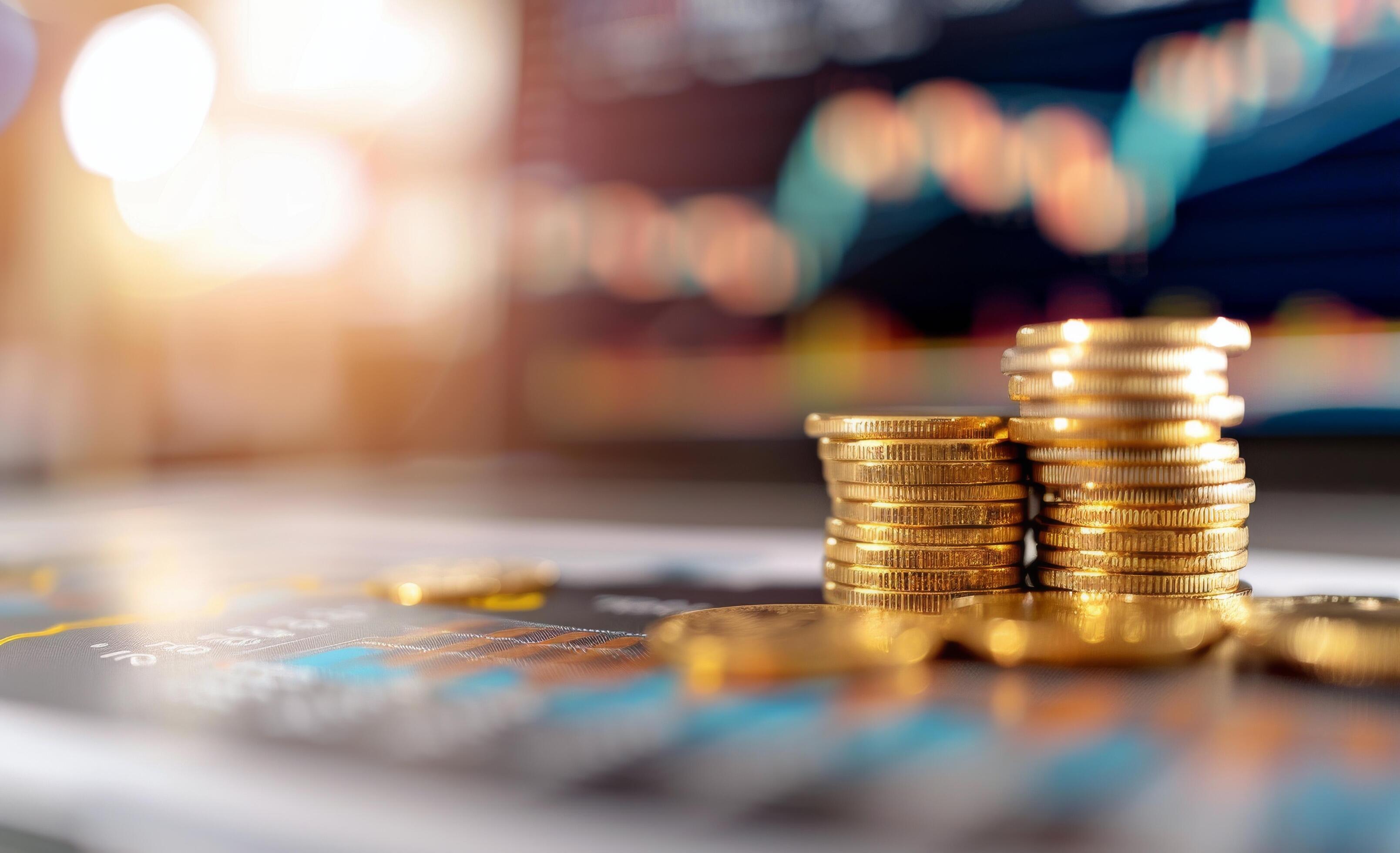 Stacked Gold Coins on Dark Background With Financial Graph in Soft Focus Stock Free