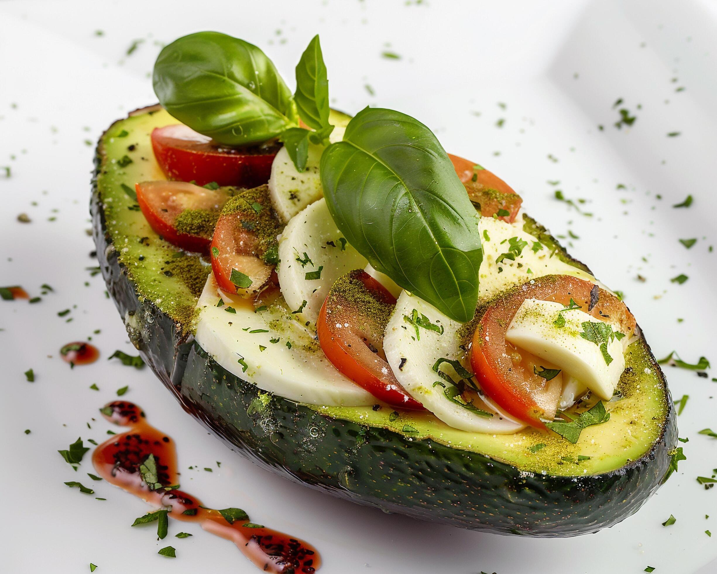 a close up of an avocado with tomatoes and basil Stock Free