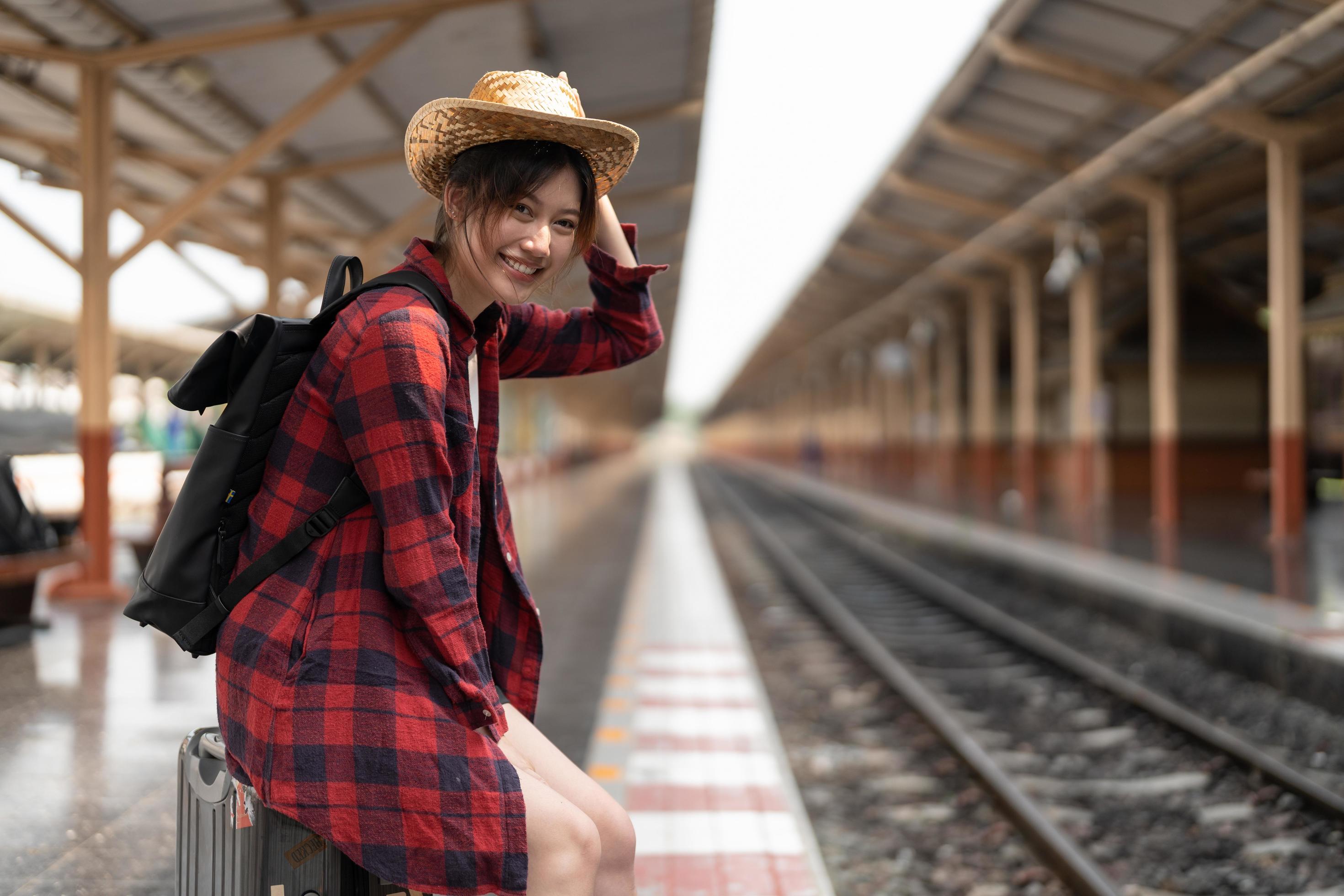 Happy asia woman traveller feeling happiness before go to travel at the train station, summer travel and lifestyle concept Stock Free