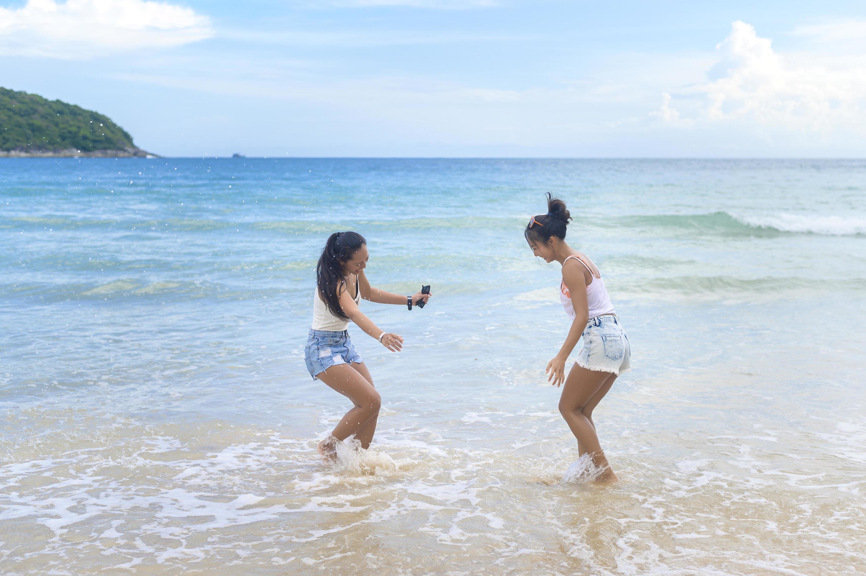 
									Two attractive women friends enjoying and relaxing on the beach, Summer, vacation, holidays, Lifestyles concept. Stock Free