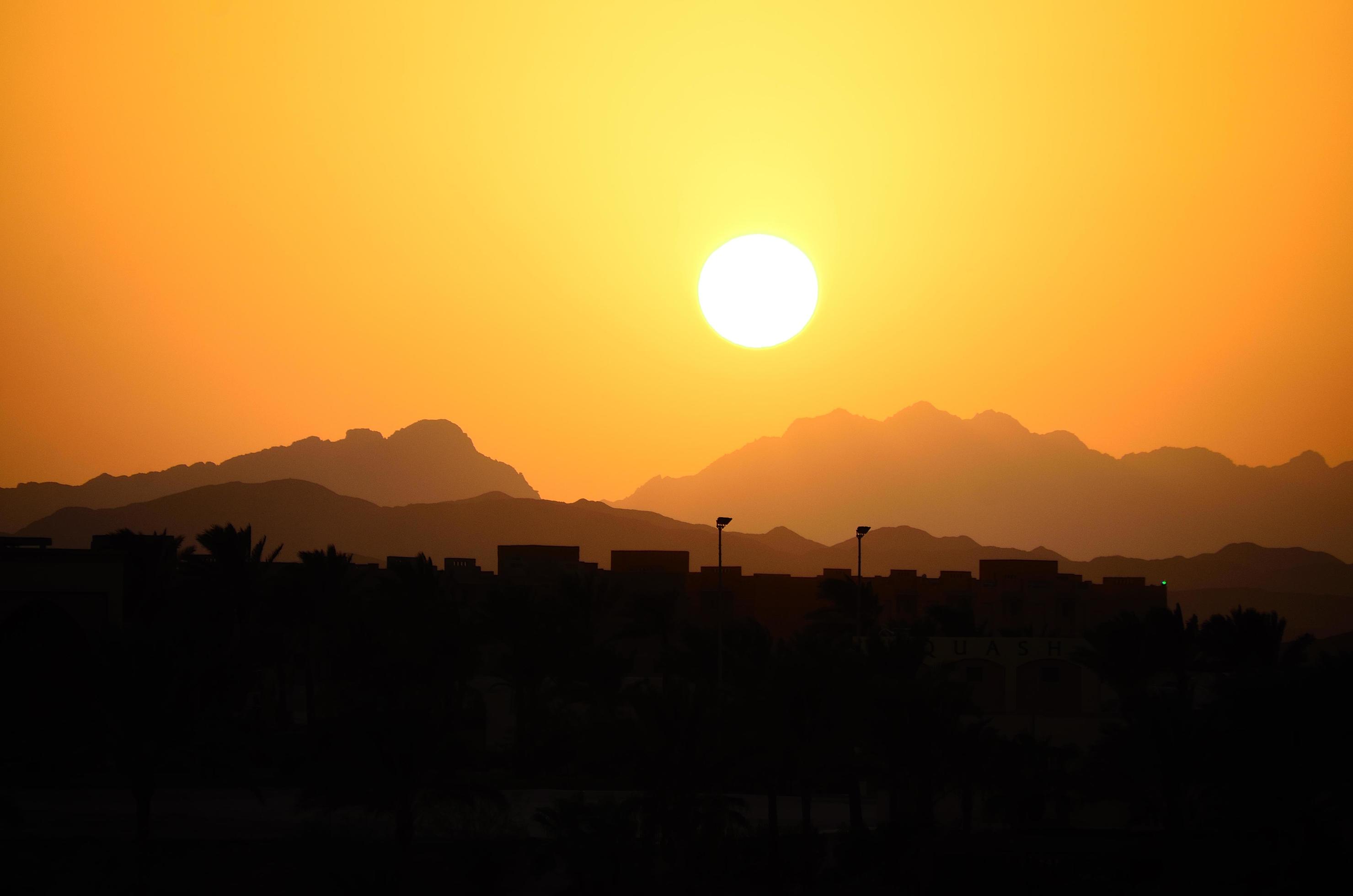 sunset with mountains and houses Stock Free