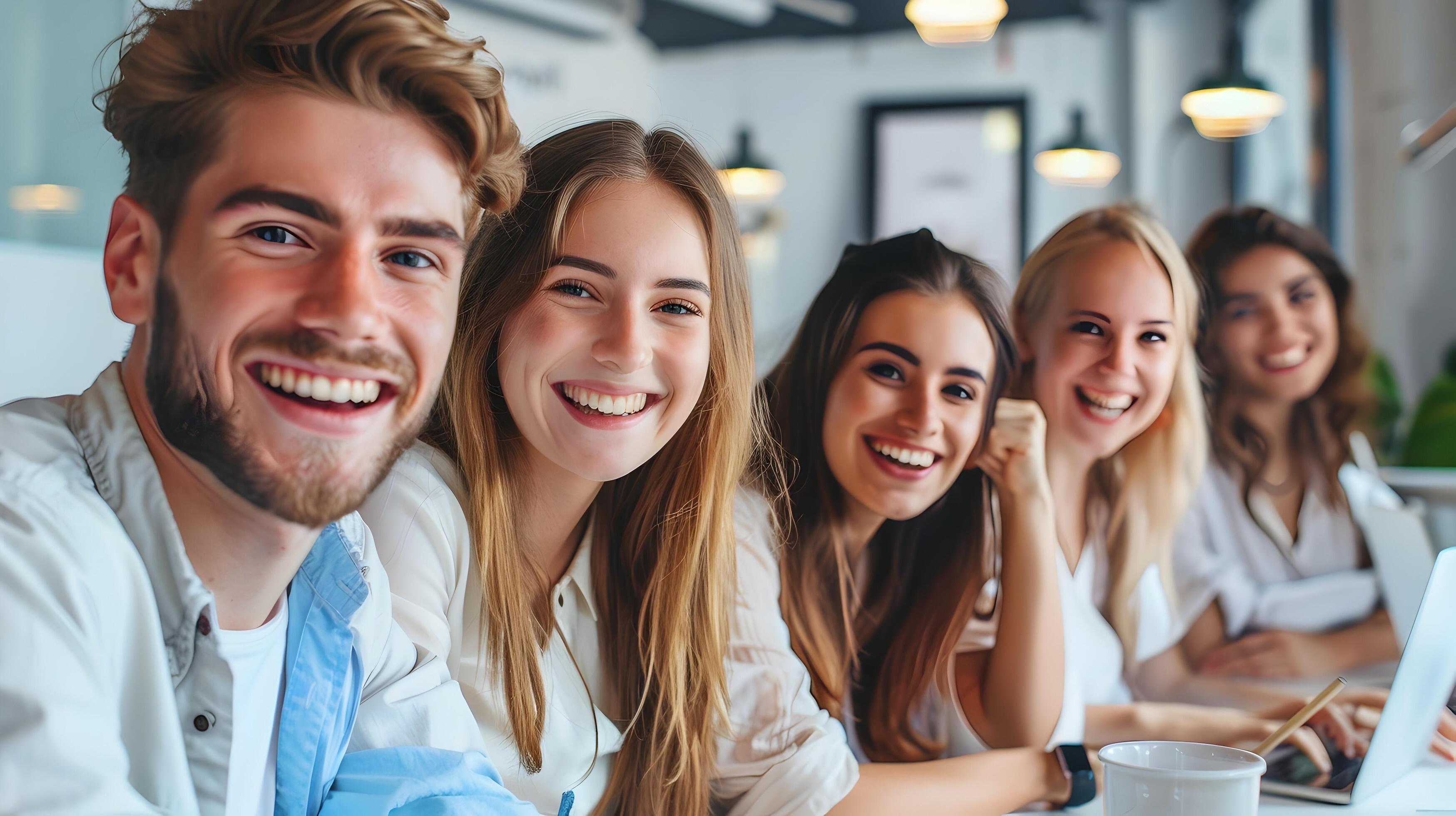 Smiling Young Professionals Engaged in Collaborative Workspace Discussion Stock Free