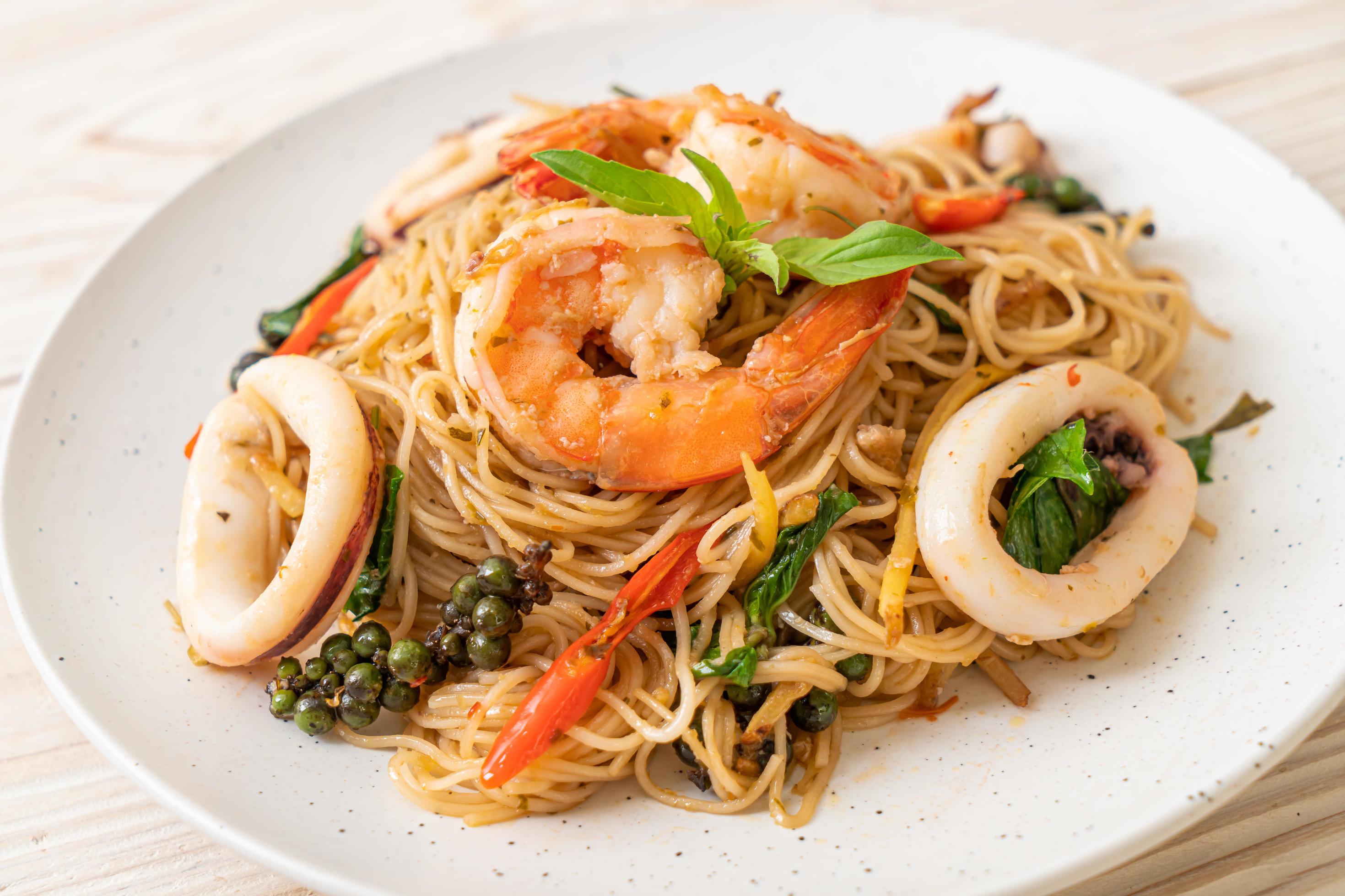 Stir-fried Chinese noodles with basil, chili, shrimp, and squid – Asian food style Stock Free