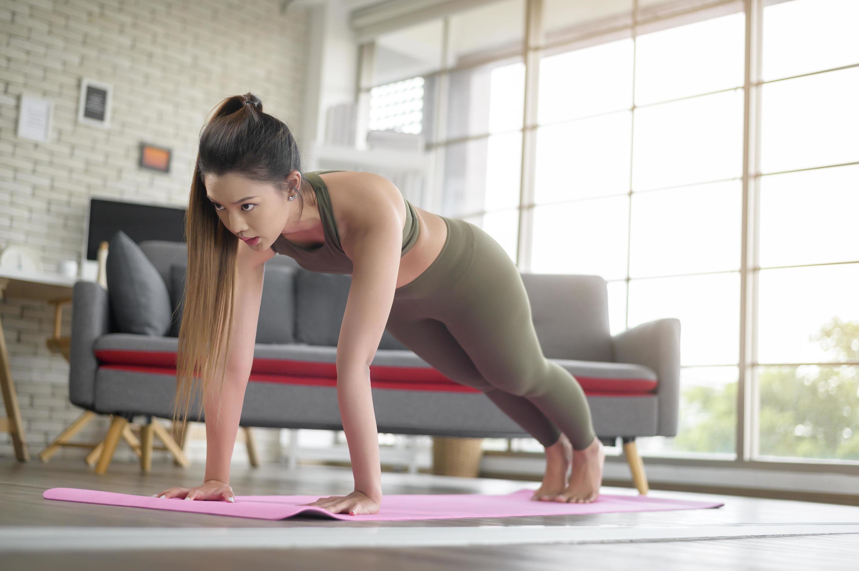 Young fitness woman in sportswear exercising at home, Healthy and Lifestyles. Stock Free