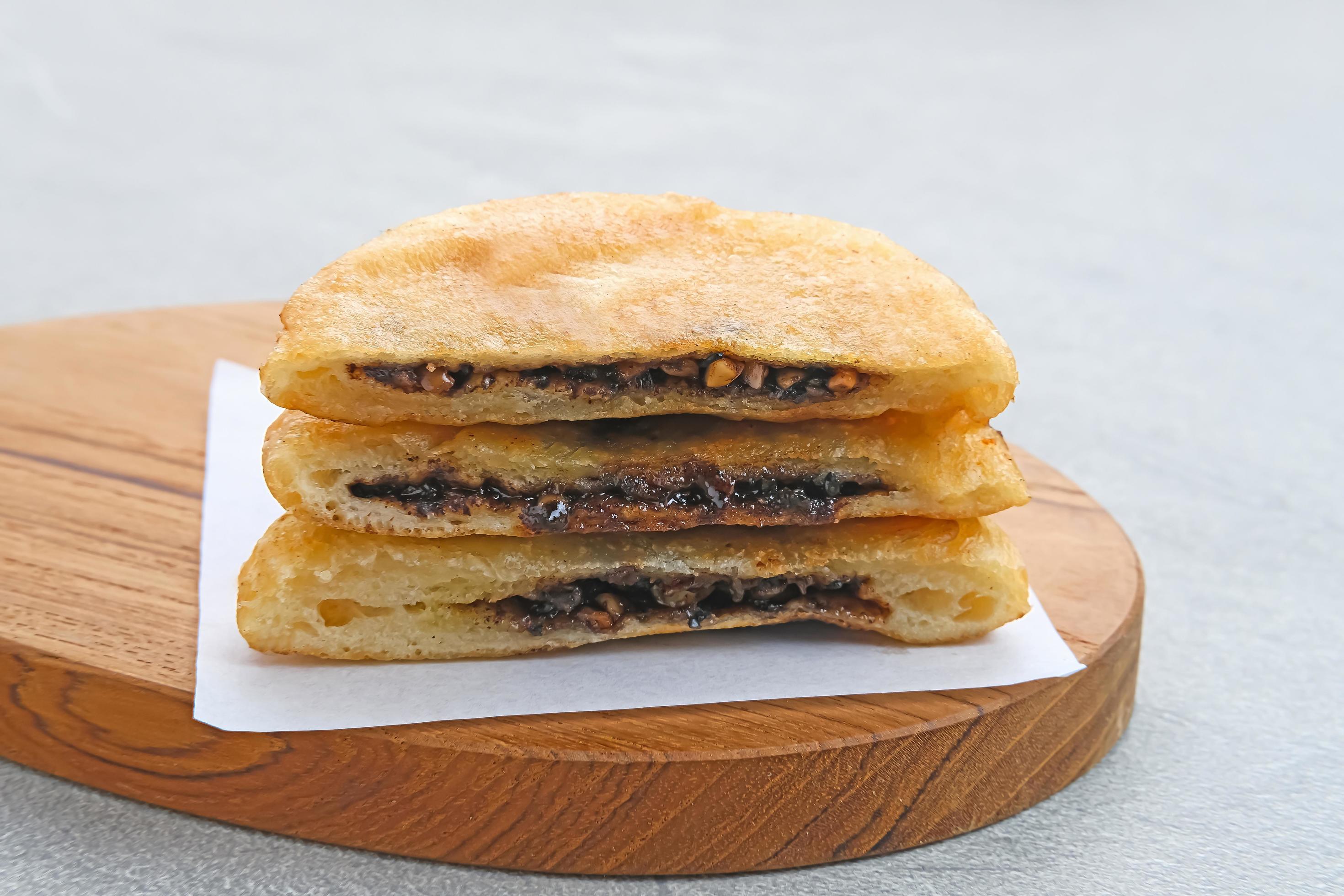 Hotteok, South Korean pancakes or fried dough with nuts and sugar filling, traditional street food. Selected focus. Stock Free