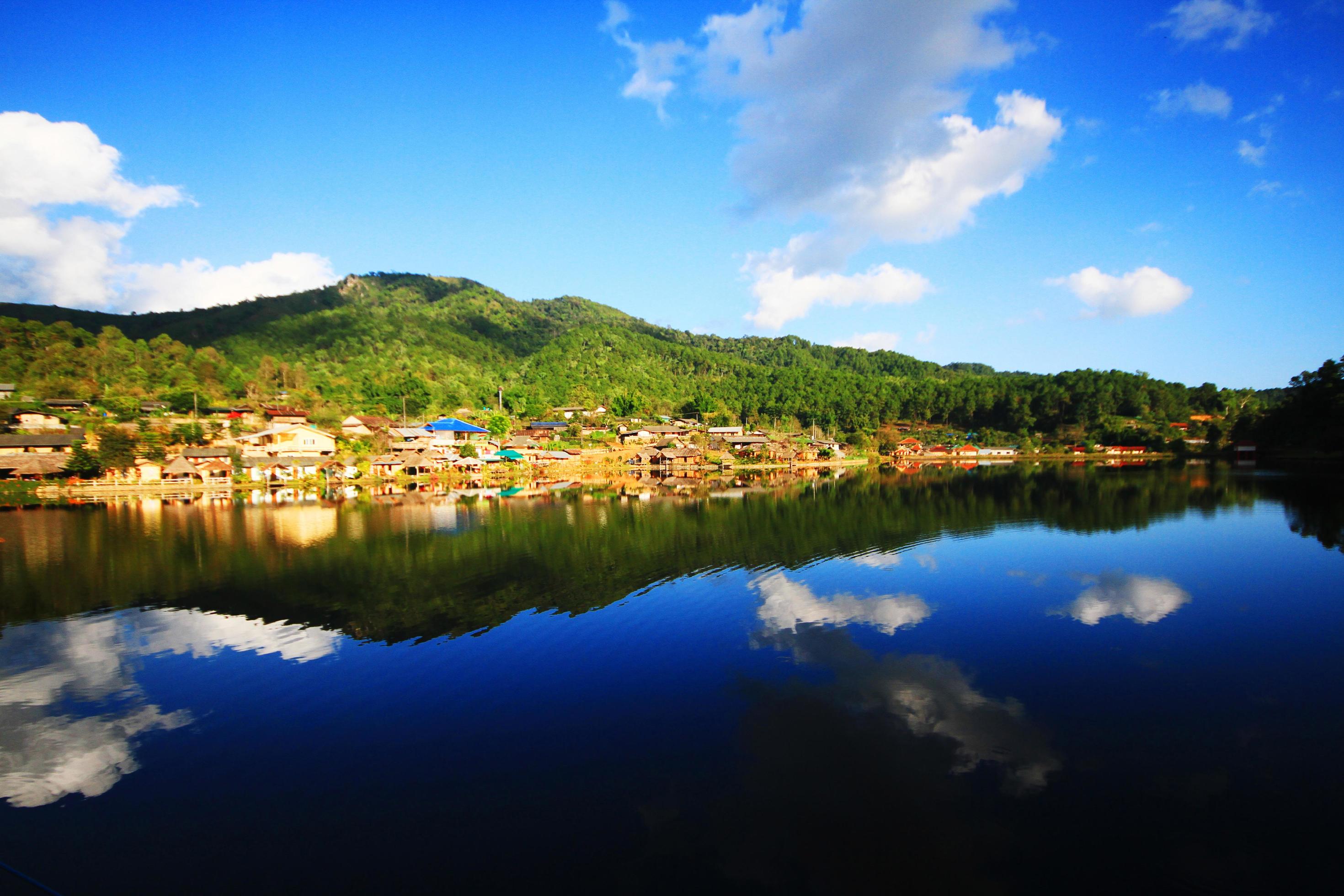 Beautiful landscape village on mountain and blue sky reflection in lake and river at Meahongson province, Thailand Stock Free