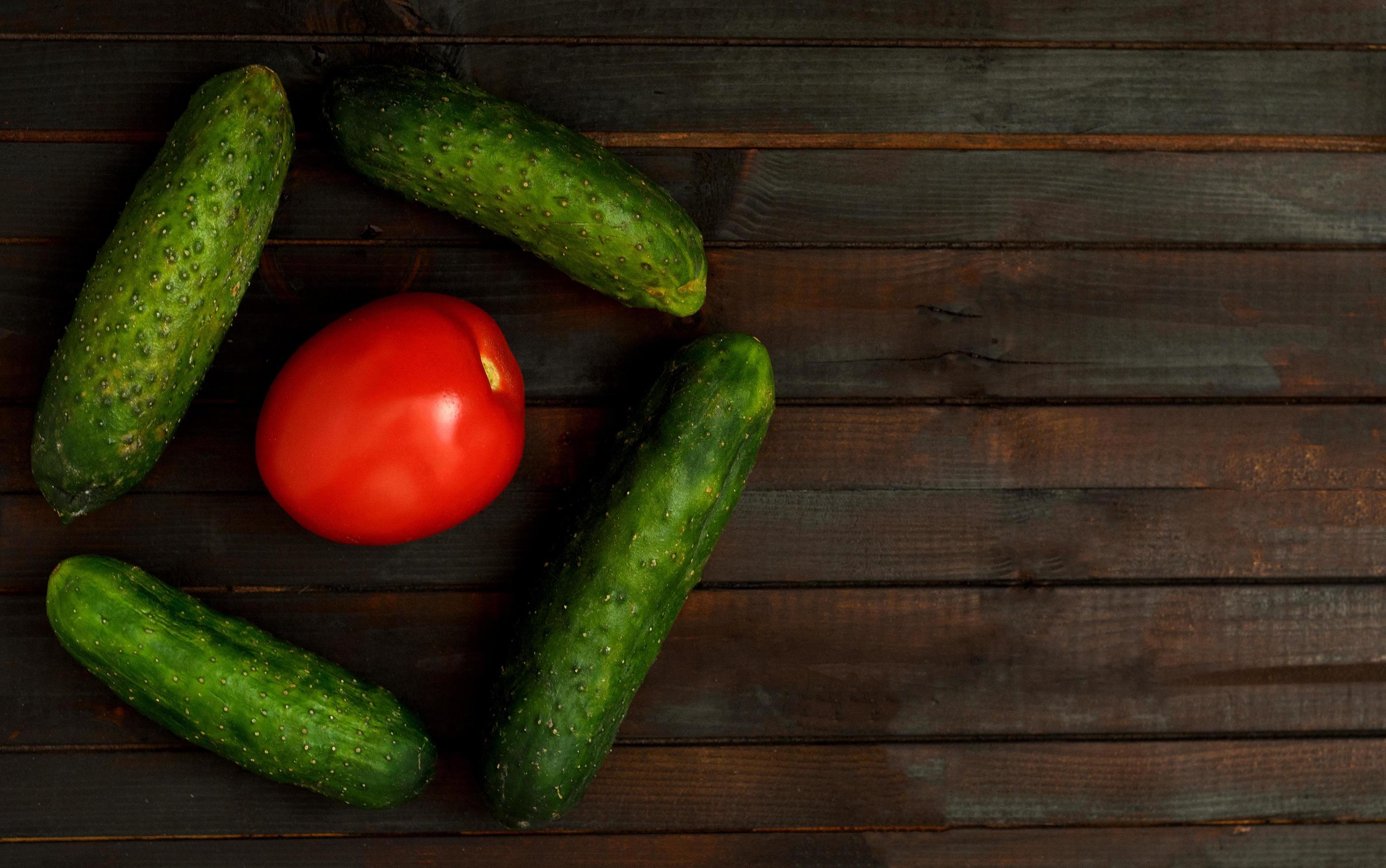 Food background with one tomato and cucumbers. Stock Free